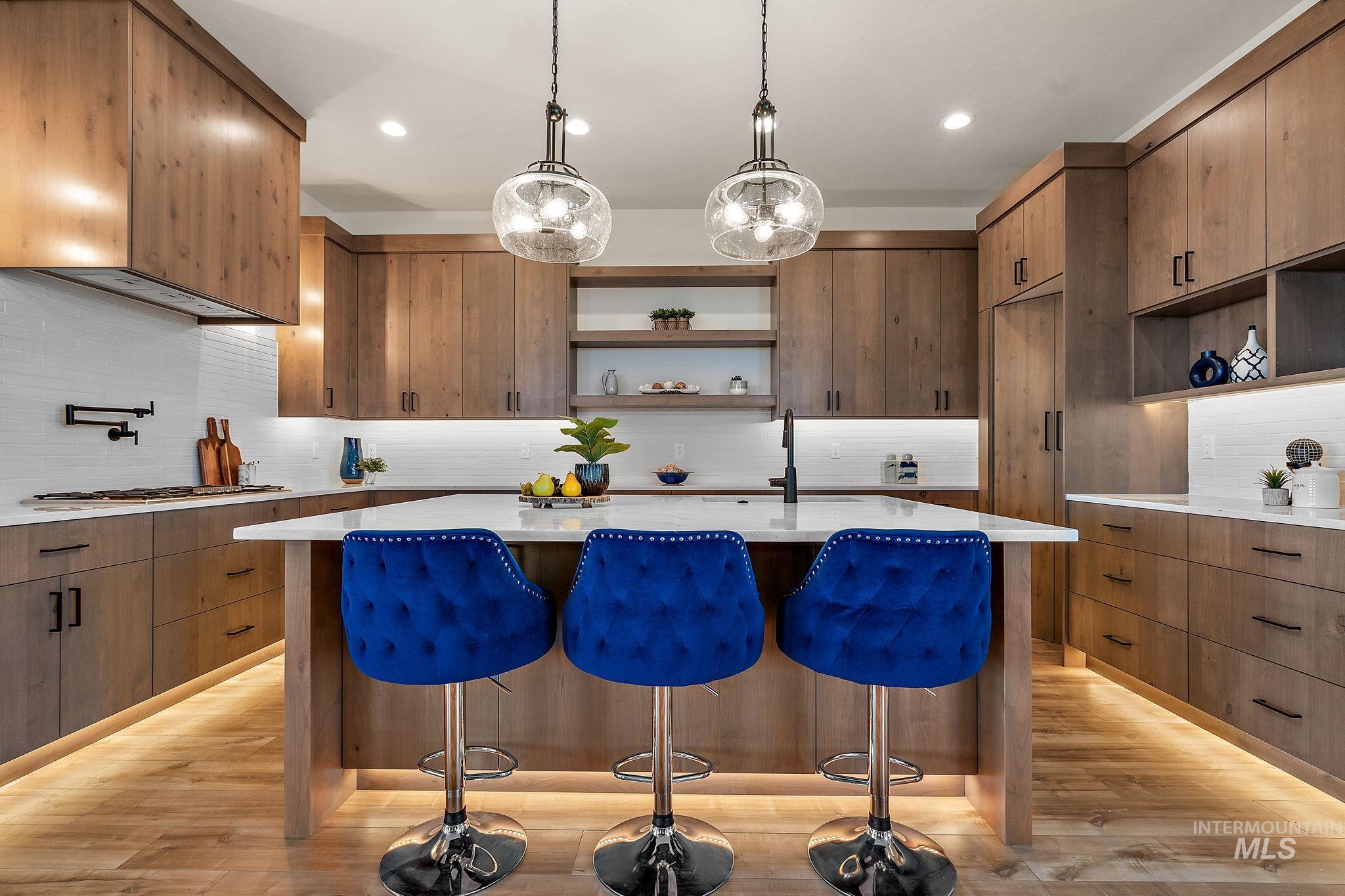 Kitchen with open shelves, backsplash, pendant lighting, light stone countertops, and recessed lighting