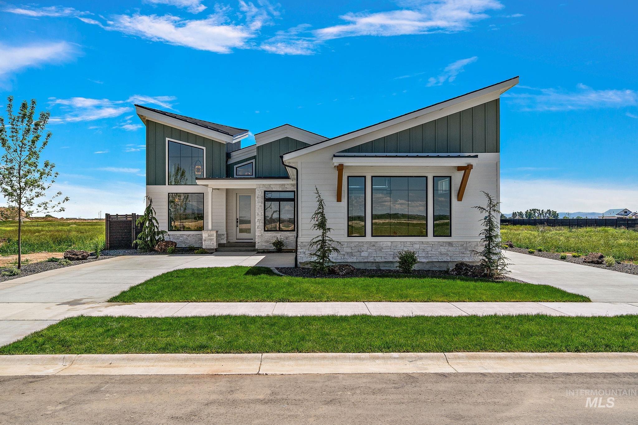 Contemporary home with stone siding, board and batten siding, and a front yard