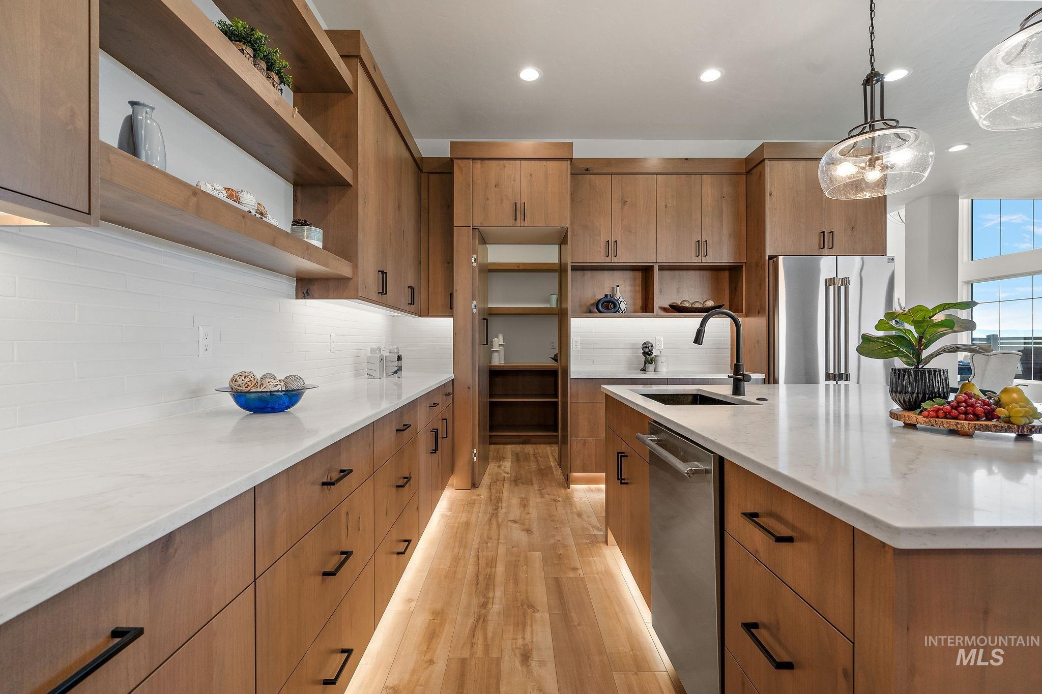 Kitchen featuring light stone counters, open shelves, hanging light fixtures, stainless steel appliances, and recessed lighting