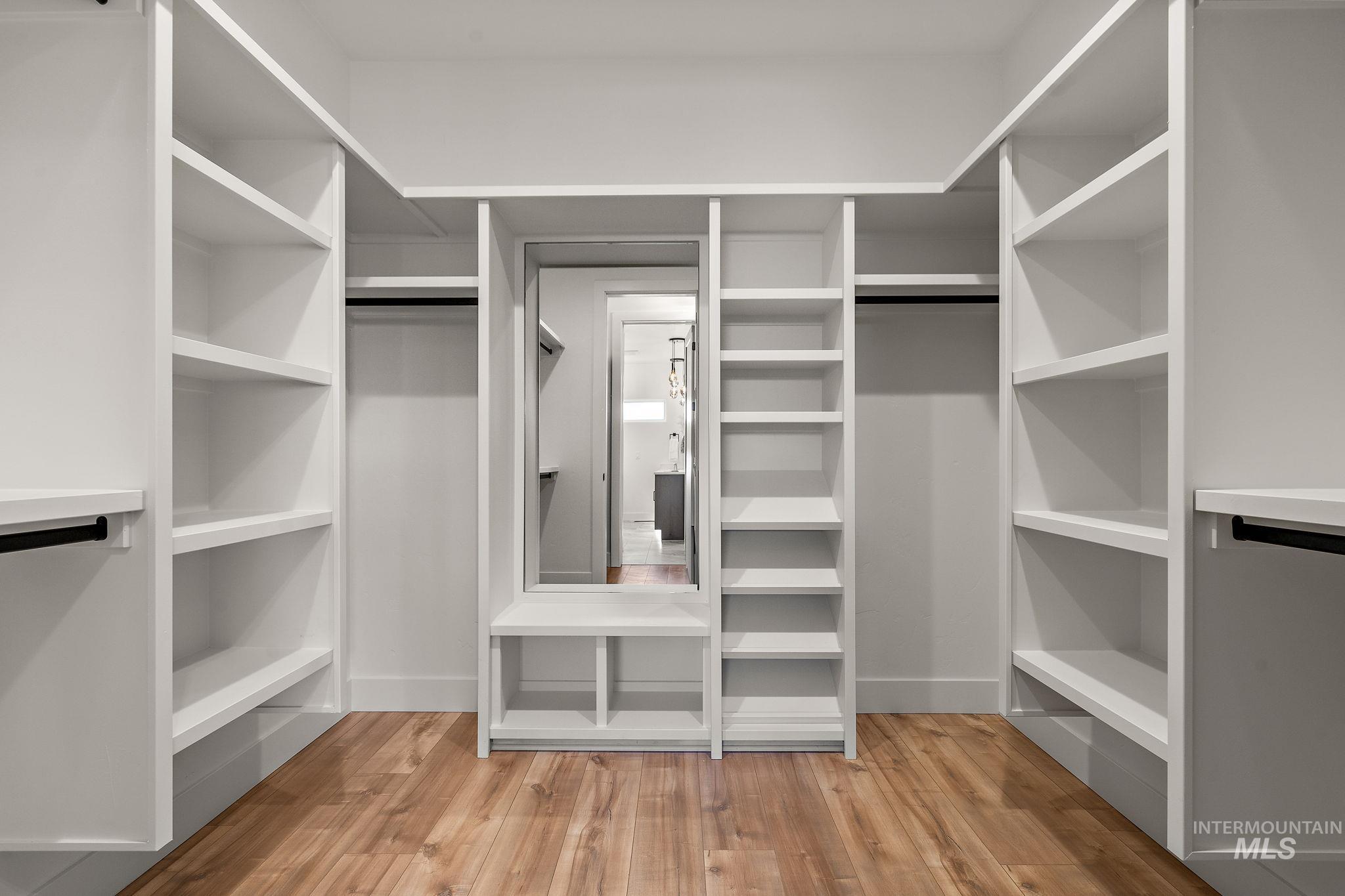 Walk in closet with light wood-type flooring