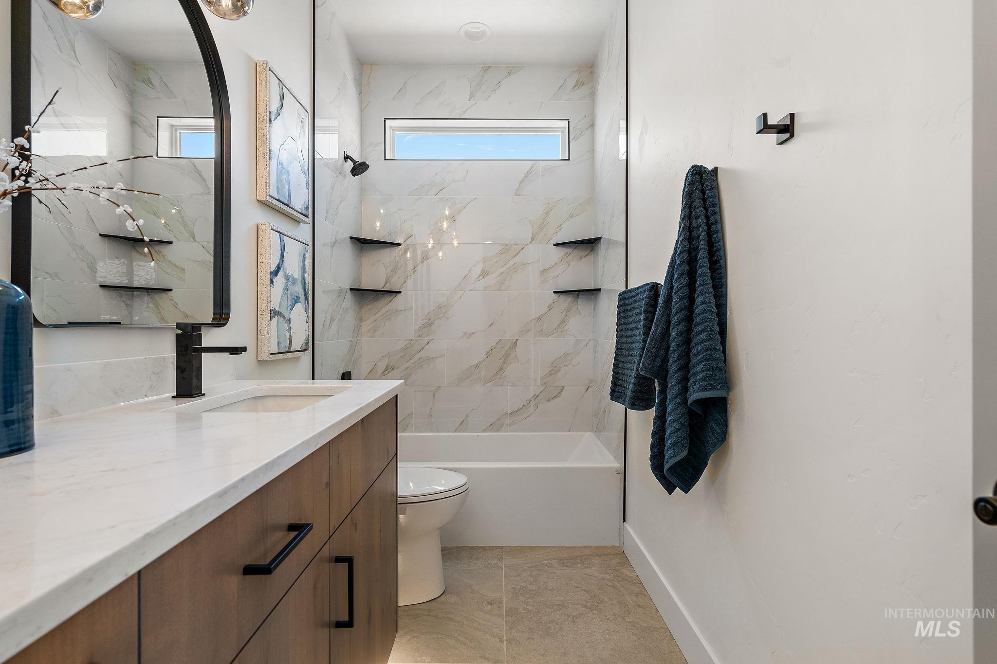 Bathroom featuring vanity and a combined bath / shower with marble appearance