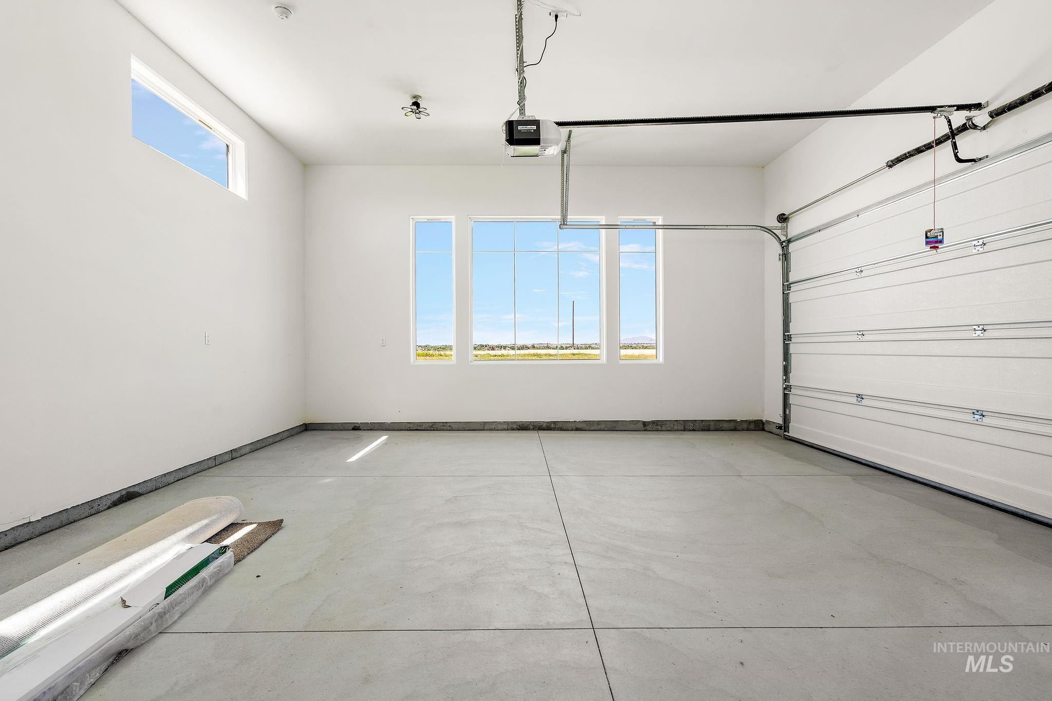 Garage with a garage door opener and baseboards