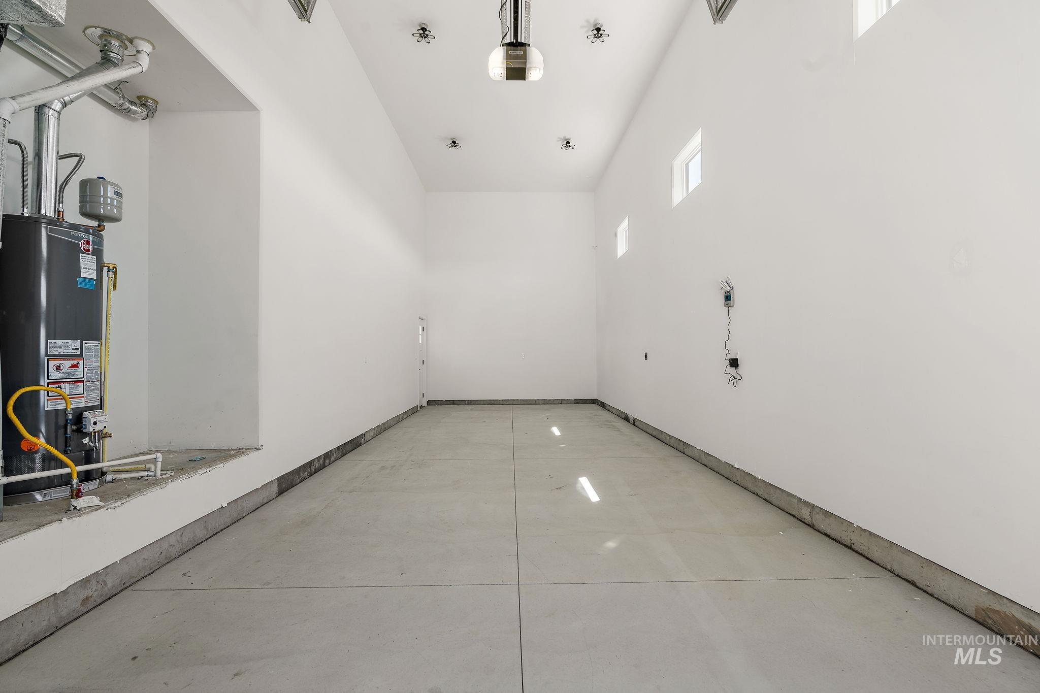 Garage with gas water heater and a garage door opener