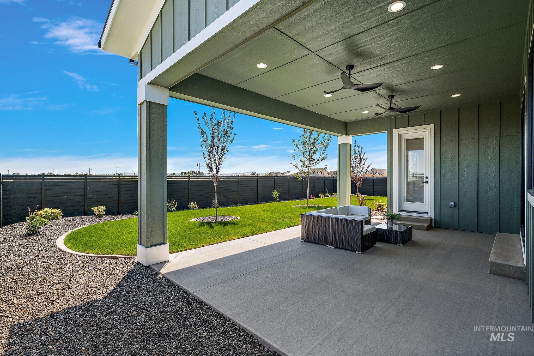 Fenced backyard with a patio area, a ceiling fan, and an outdoor hangout area