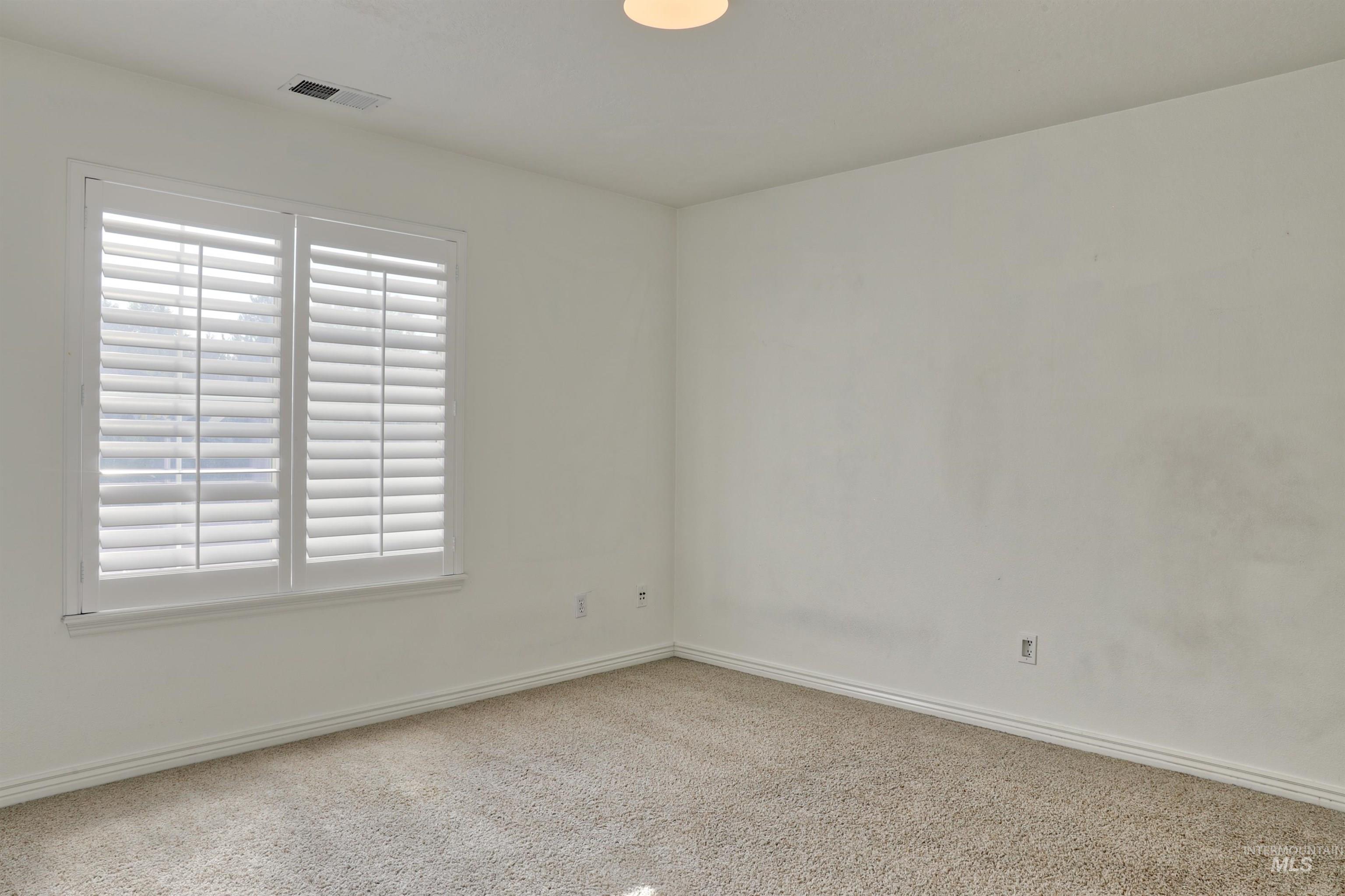 Carpeted empty room with baseboards