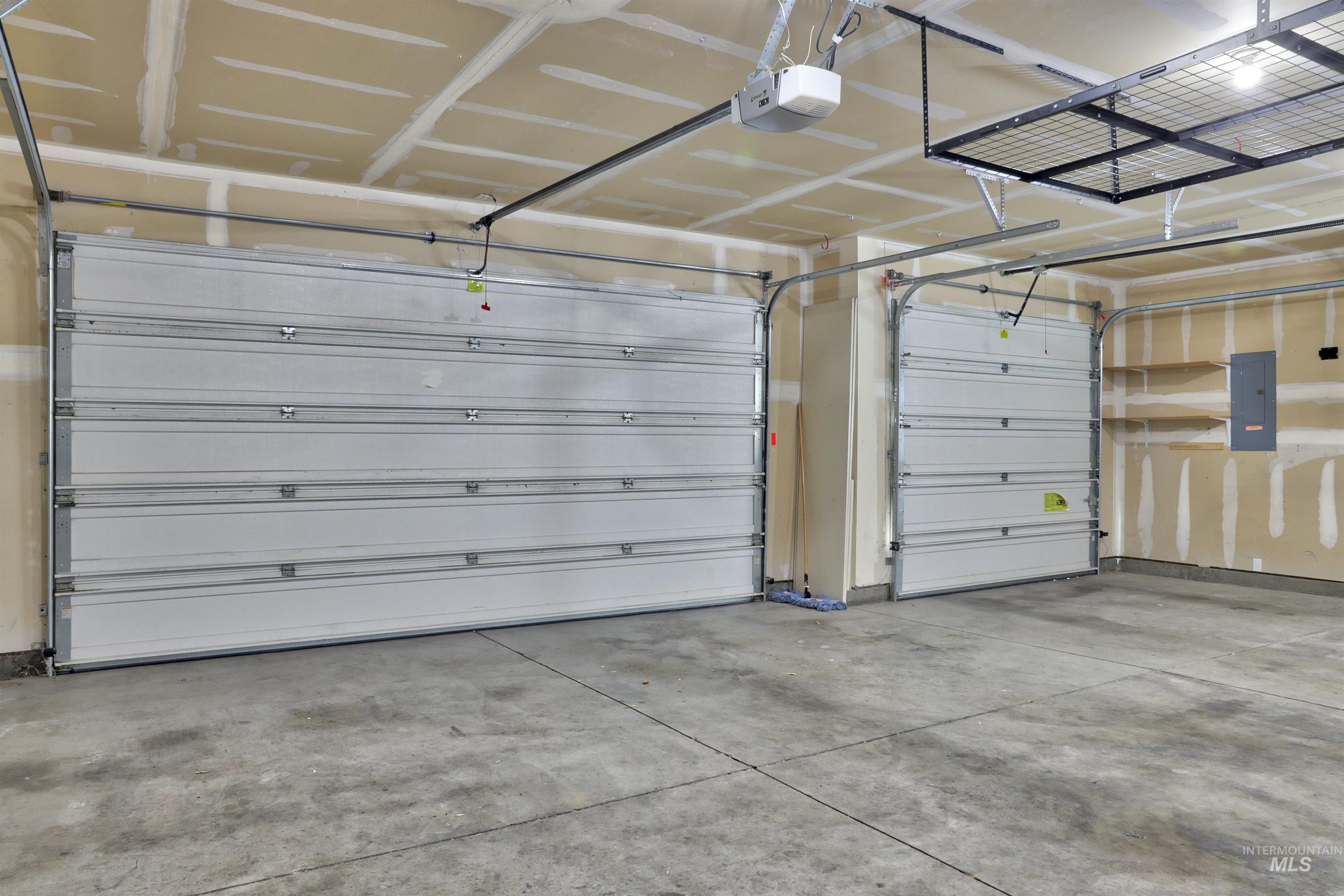 Garage featuring electric panel and a garage door opener