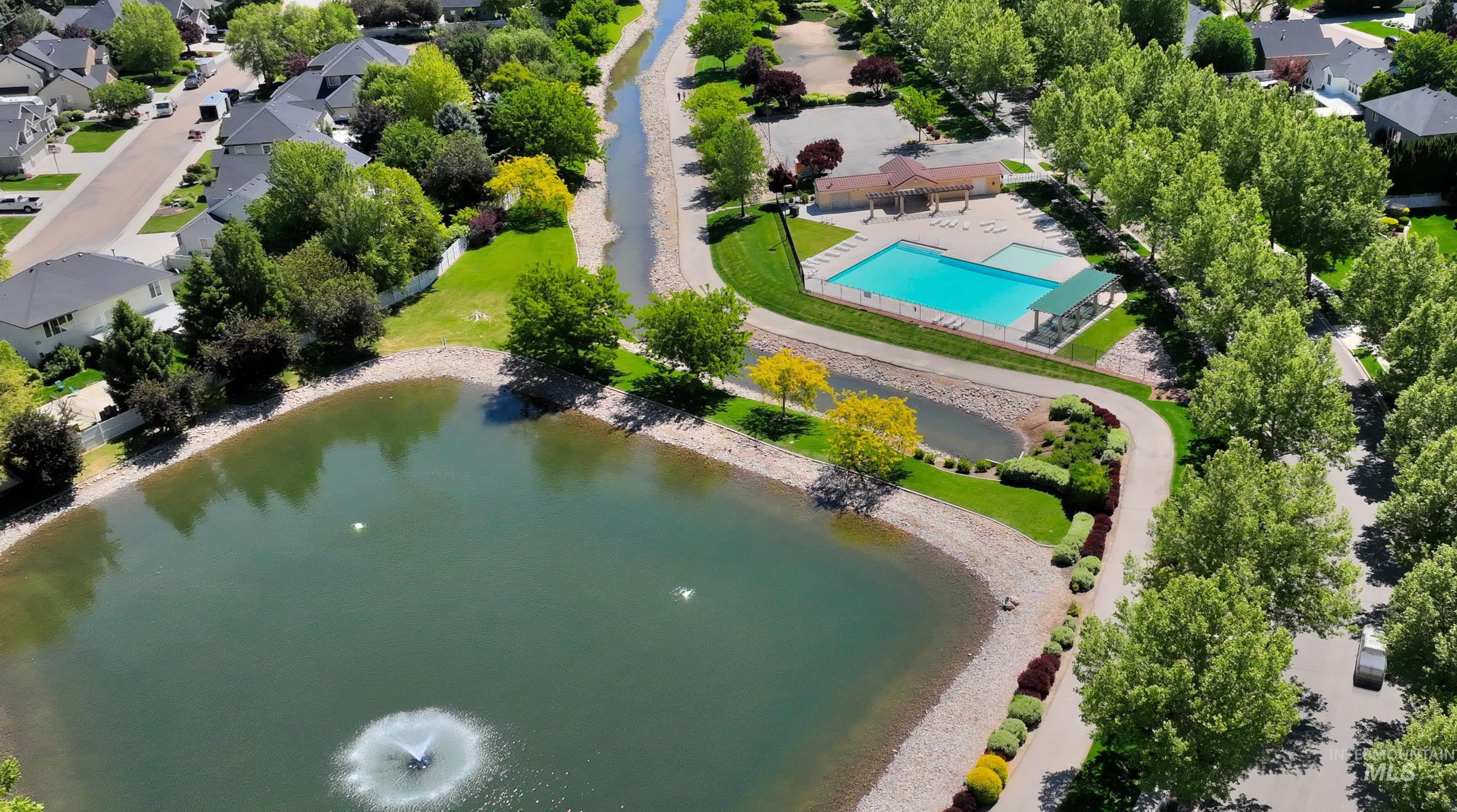 Drone / aerial view of a nearby body of water and a pool