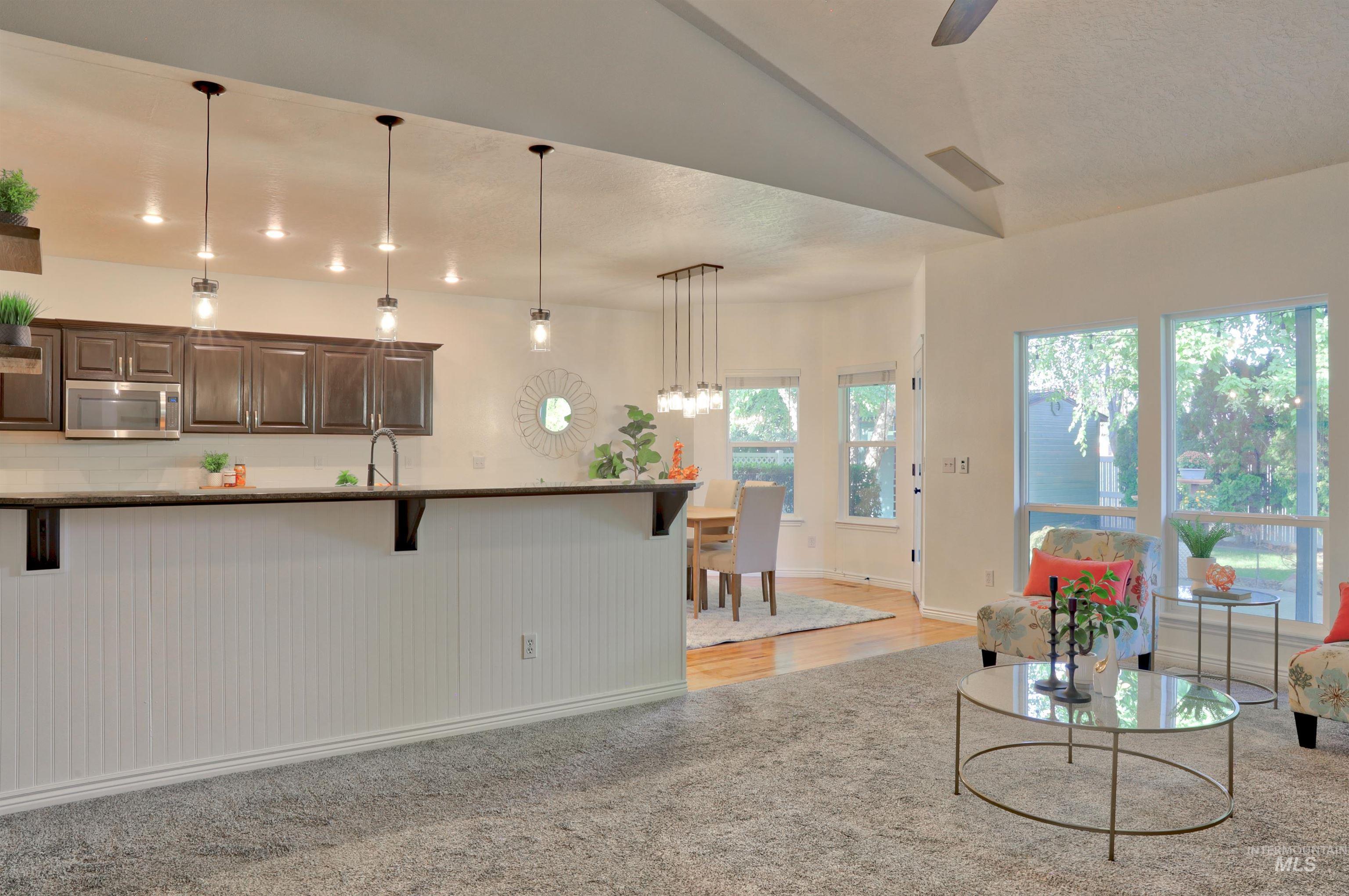 Living room featuring ceiling fan, light wood finished floors, and a textured ceiling