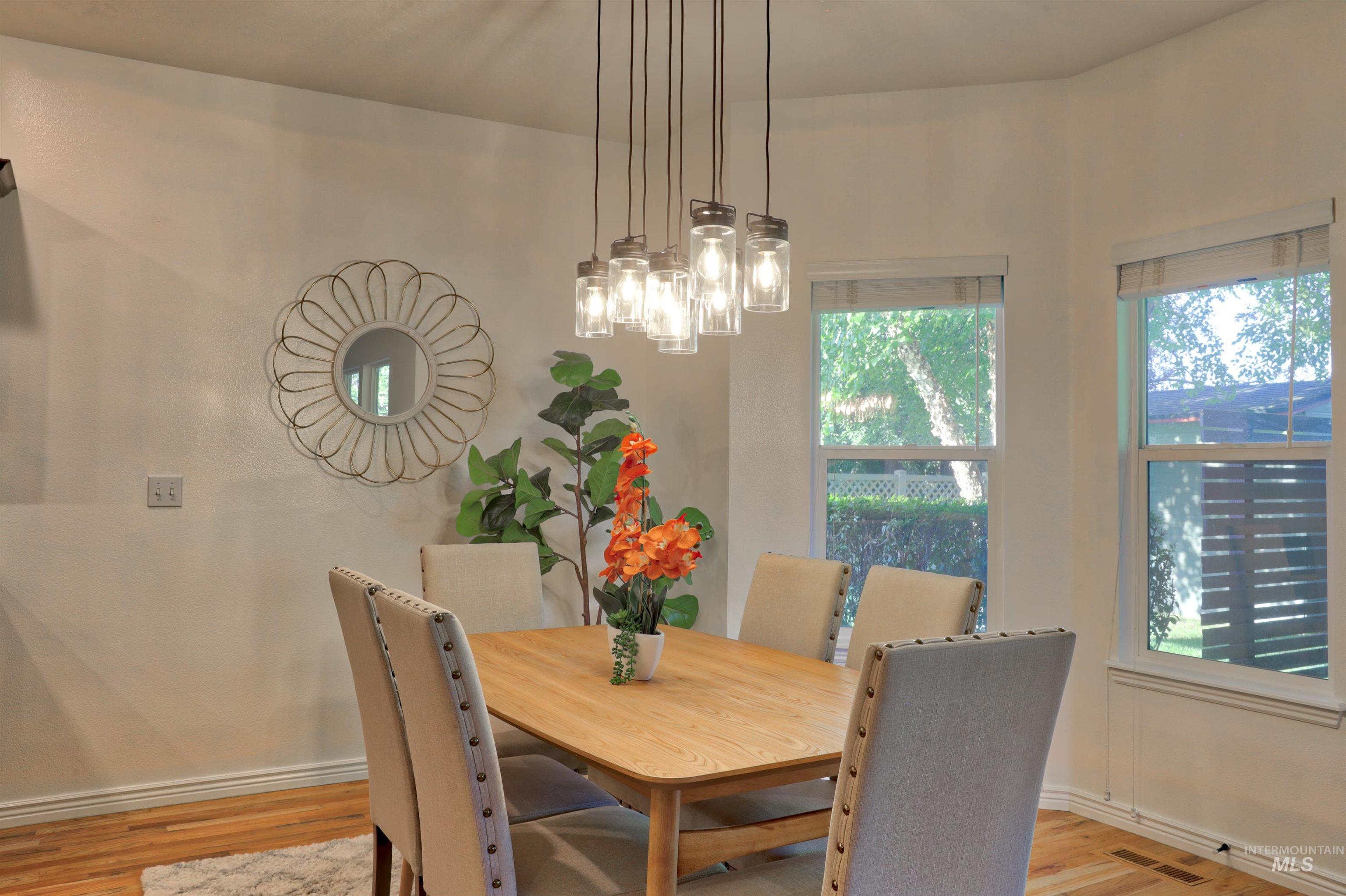 Dining room with light wood-type flooring and a chandelier