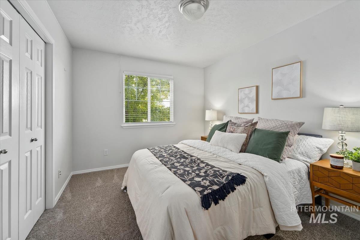 Bedroom with carpet flooring, a closet, and a textured ceiling