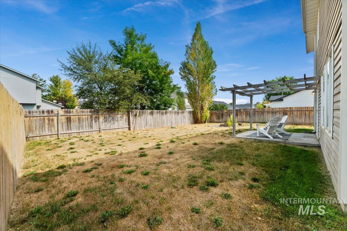 Fenced backyard with a pergola and a patio area