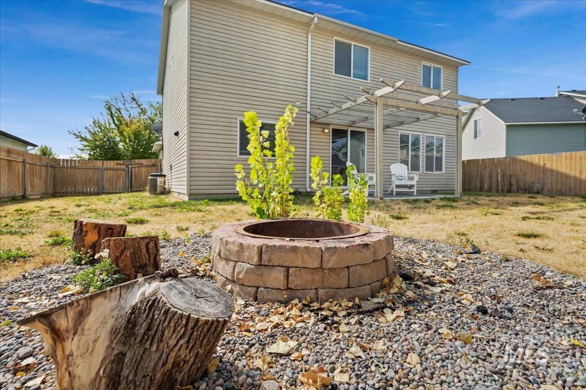 Back of house featuring a fenced backyard and an outdoor fire pit