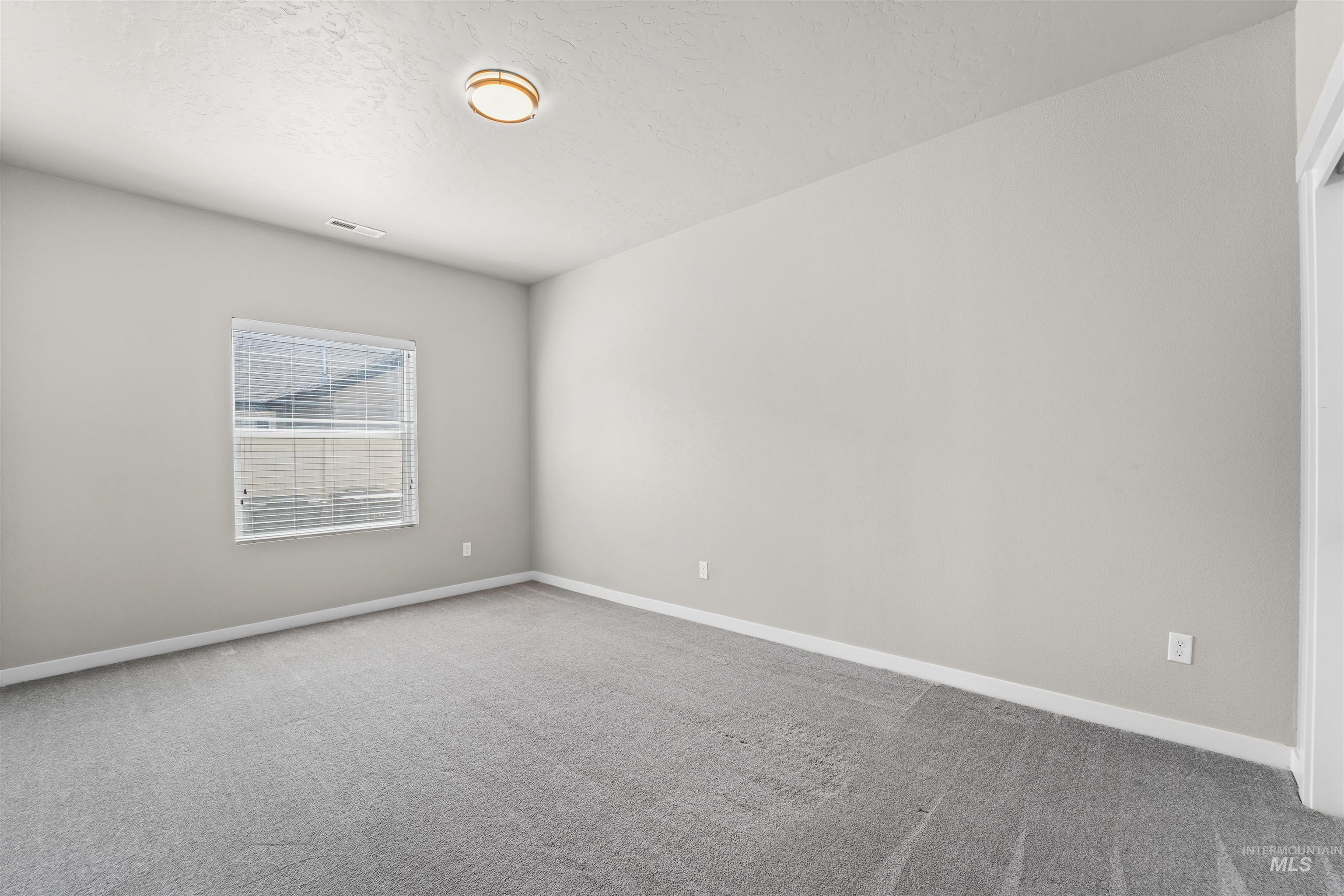 Spare room featuring carpet flooring and a textured ceiling