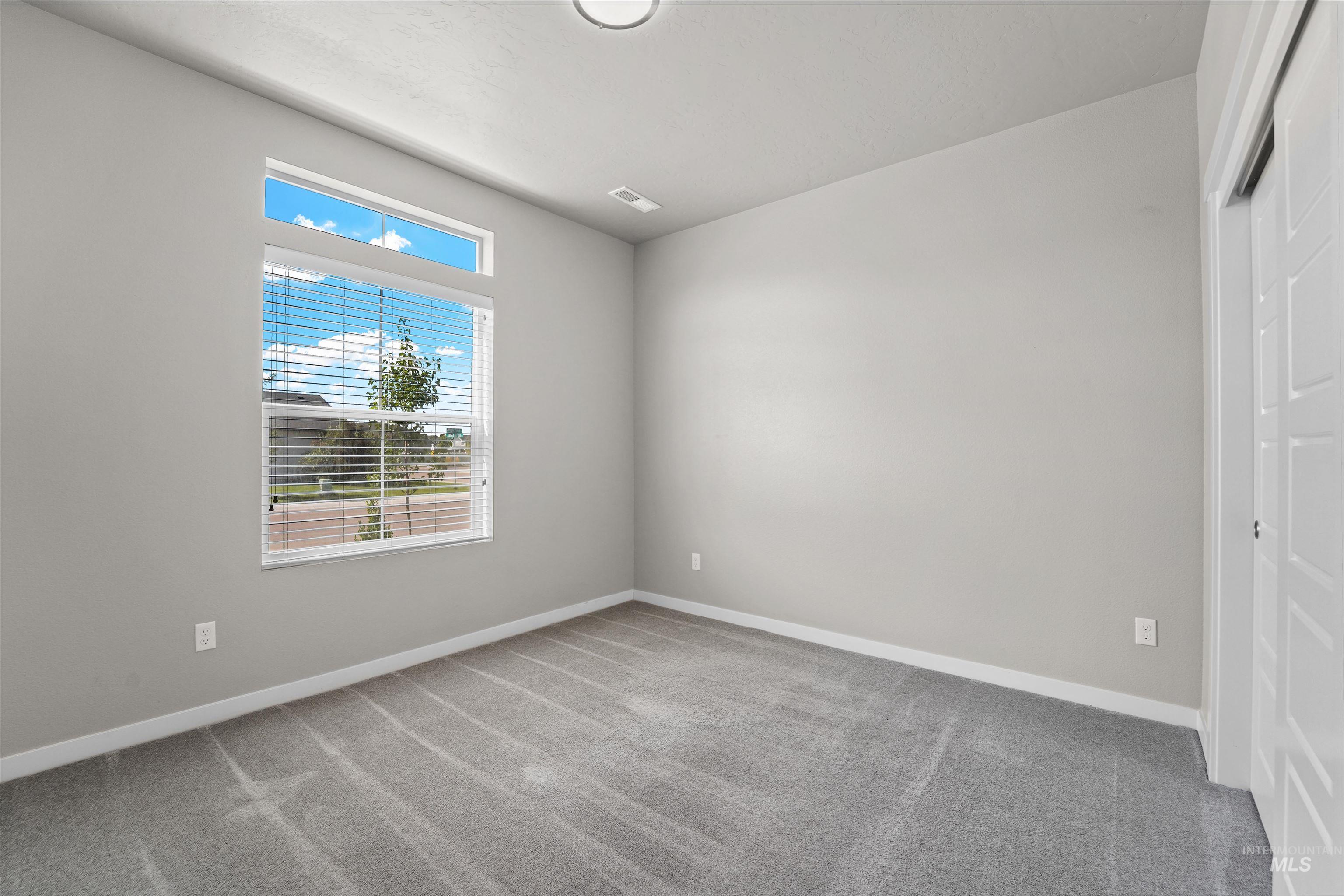 Unfurnished bedroom with light colored carpet and a closet