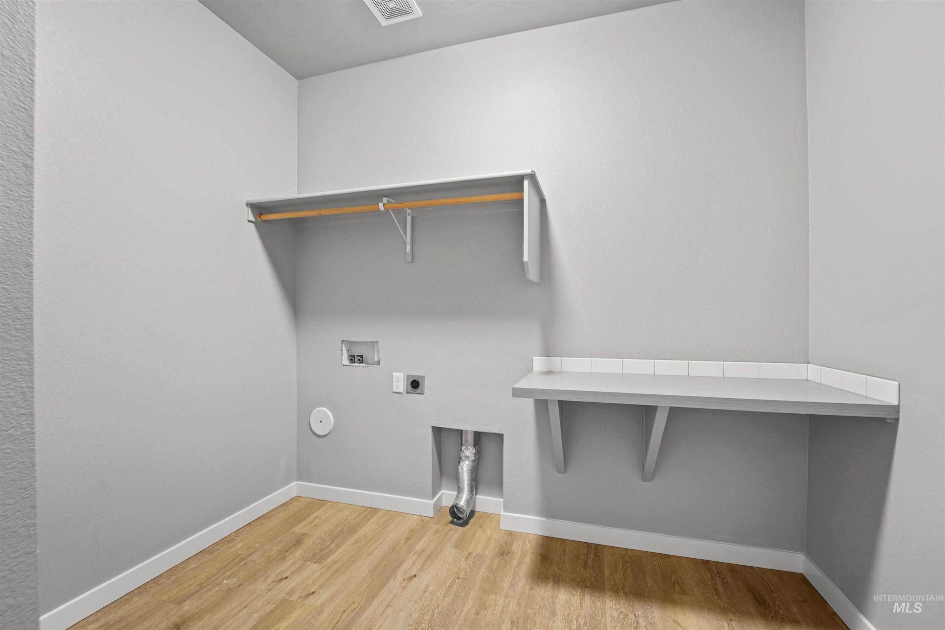 Washroom featuring light wood-style flooring, hookup for an electric dryer, and hookup for a washing machine
