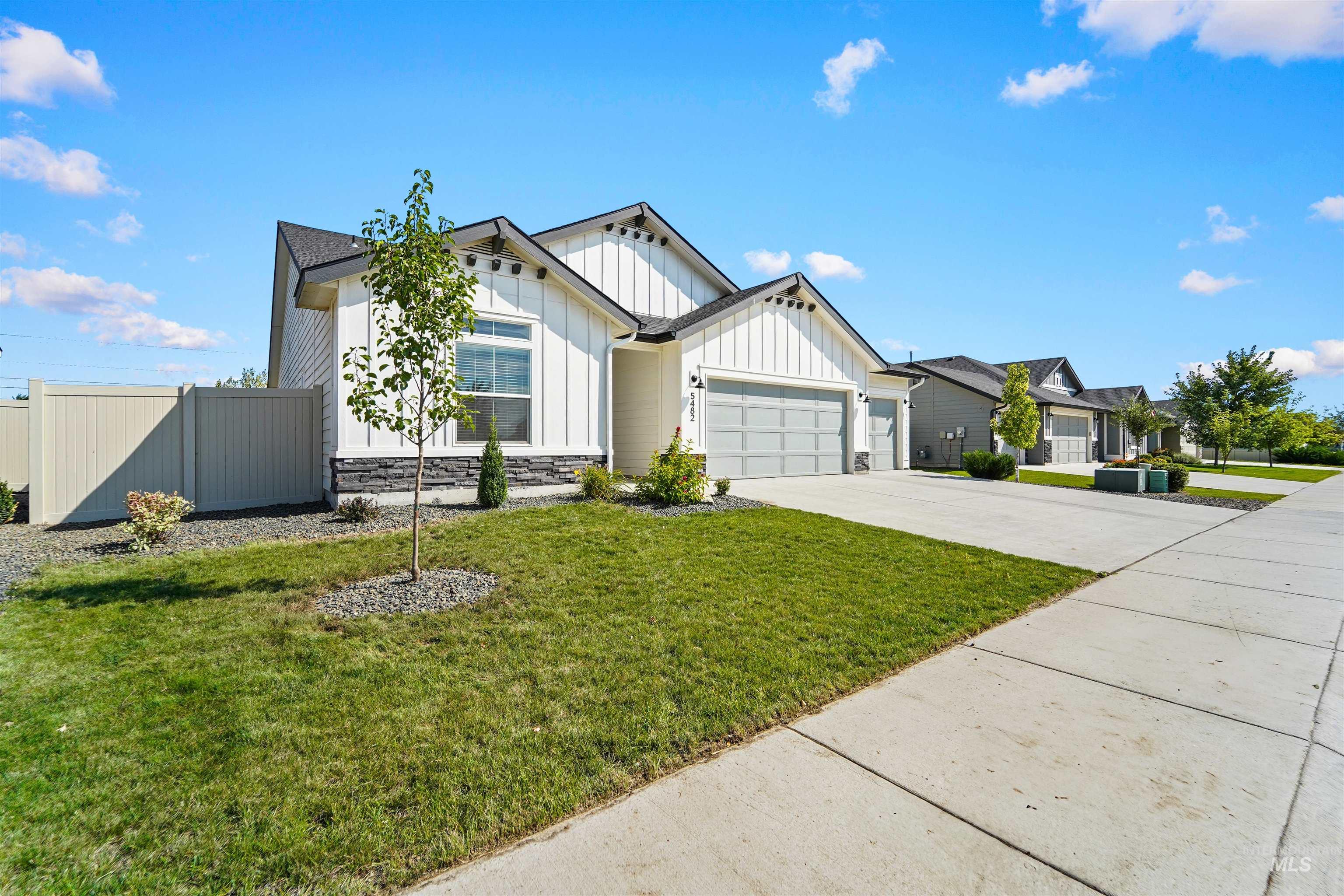 View of front of house featuring board and batten siding, concrete driveway, stone siding, and a garage
