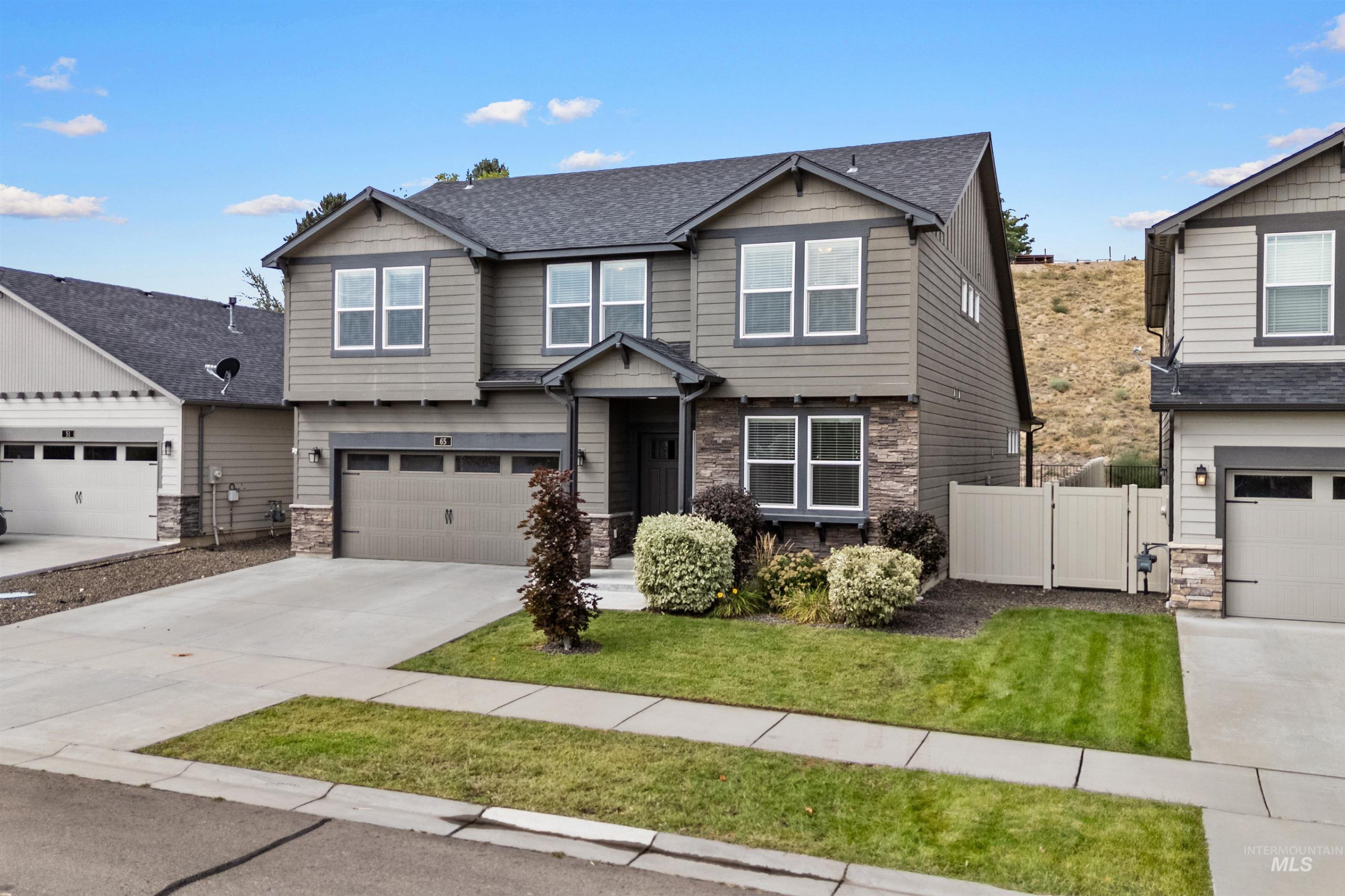 Craftsman inspired home featuring stone siding, concrete driveway, roof with shingles, a garage, and a gate