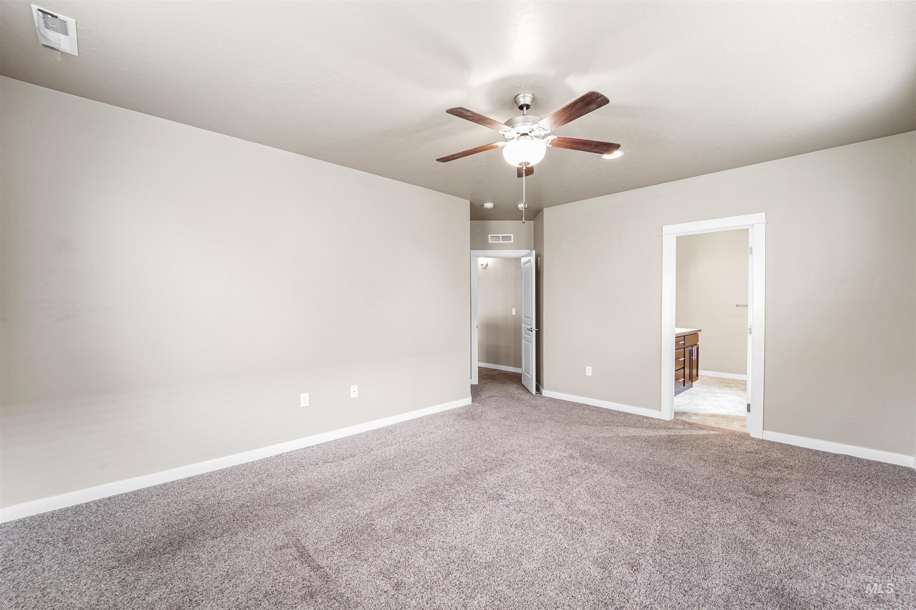 Unfurnished bedroom featuring carpet flooring and ceiling fan