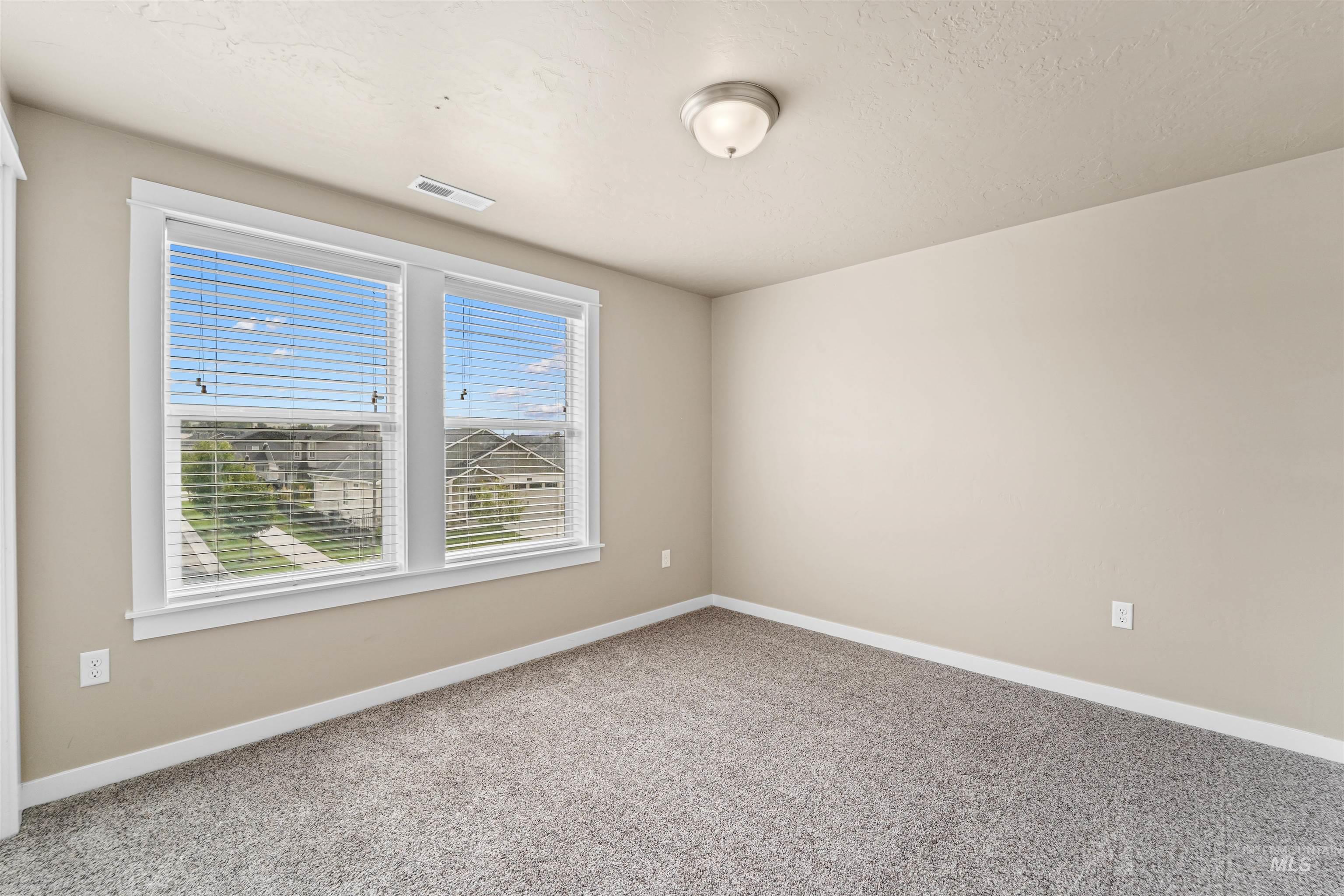 Carpeted empty room with baseboards