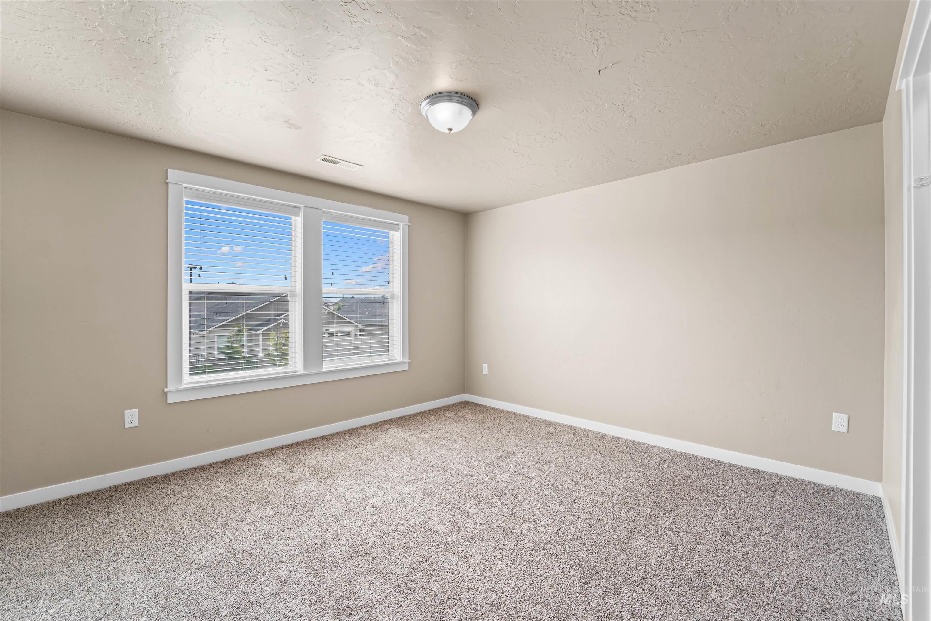 Spare room with light carpet and a textured ceiling