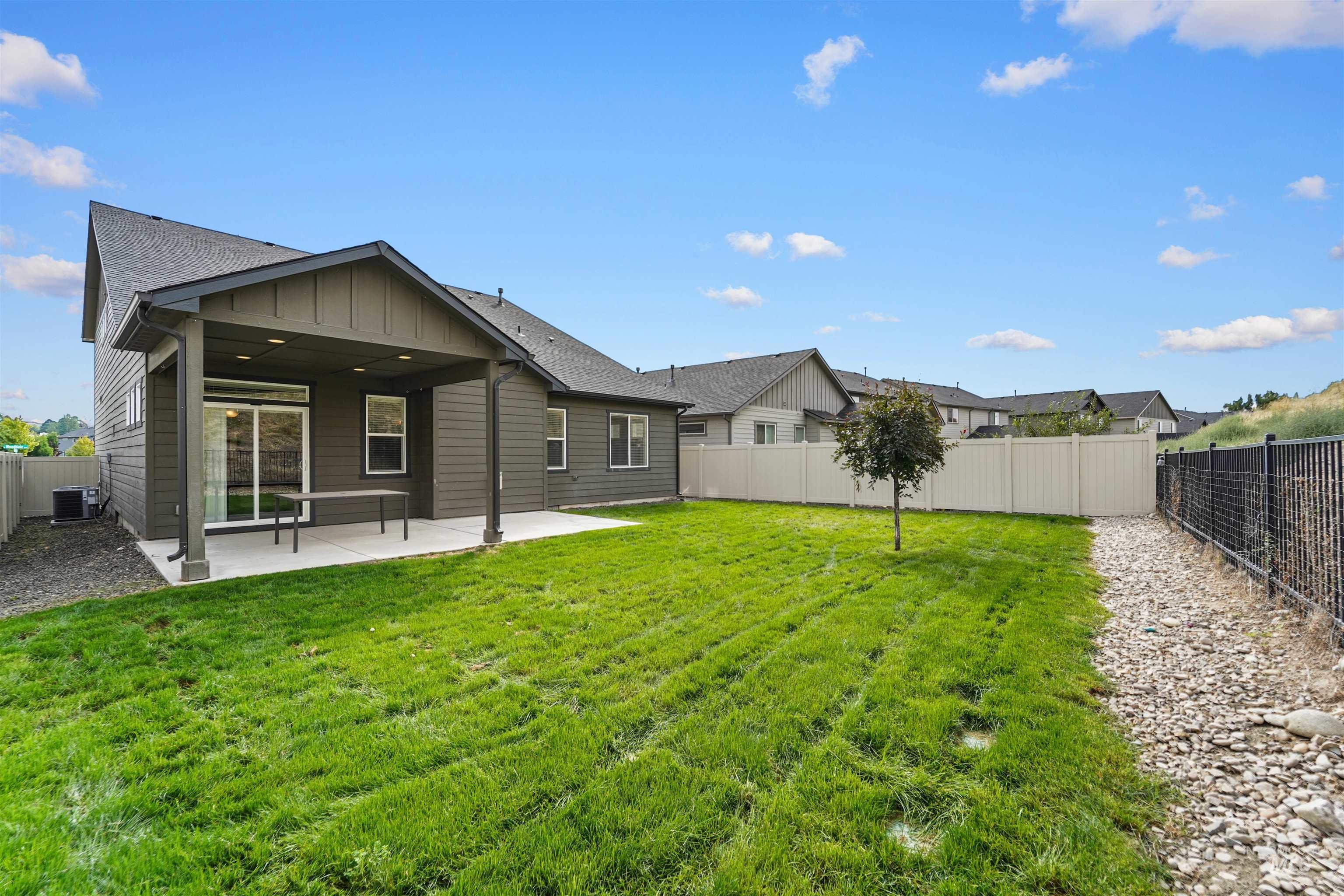Back of property featuring a fenced backyard, a patio, board and batten siding, and roof with shingles