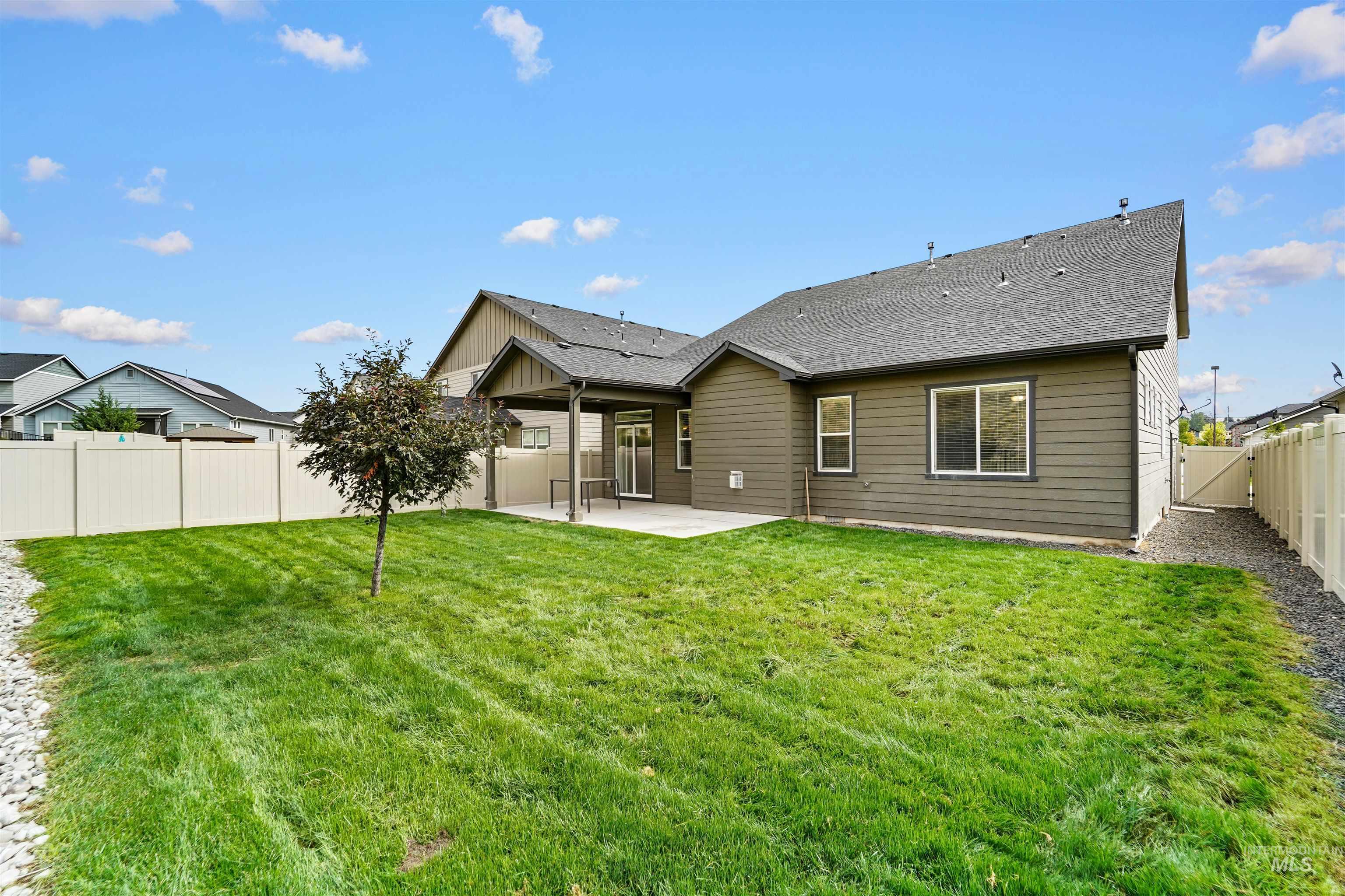 Back of property featuring a patio area, a fenced backyard, and a shingled roof