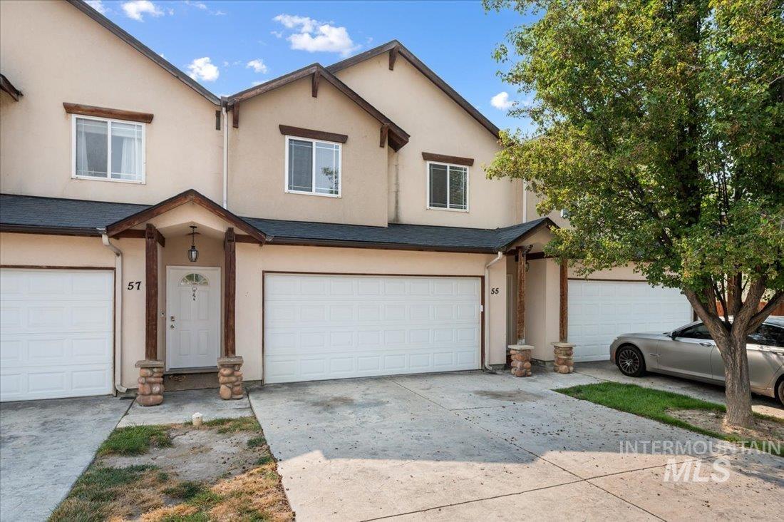 Traditional home with stucco siding, concrete driveway, and a garage