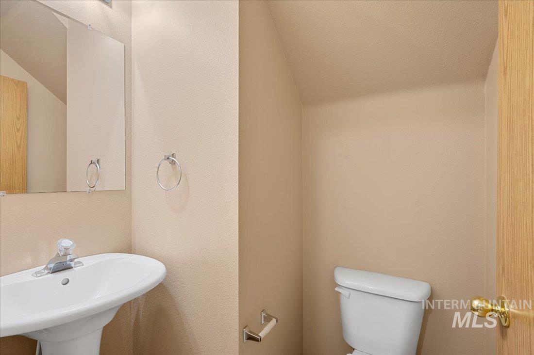 Half bathroom with a textured wall and a textured ceiling
