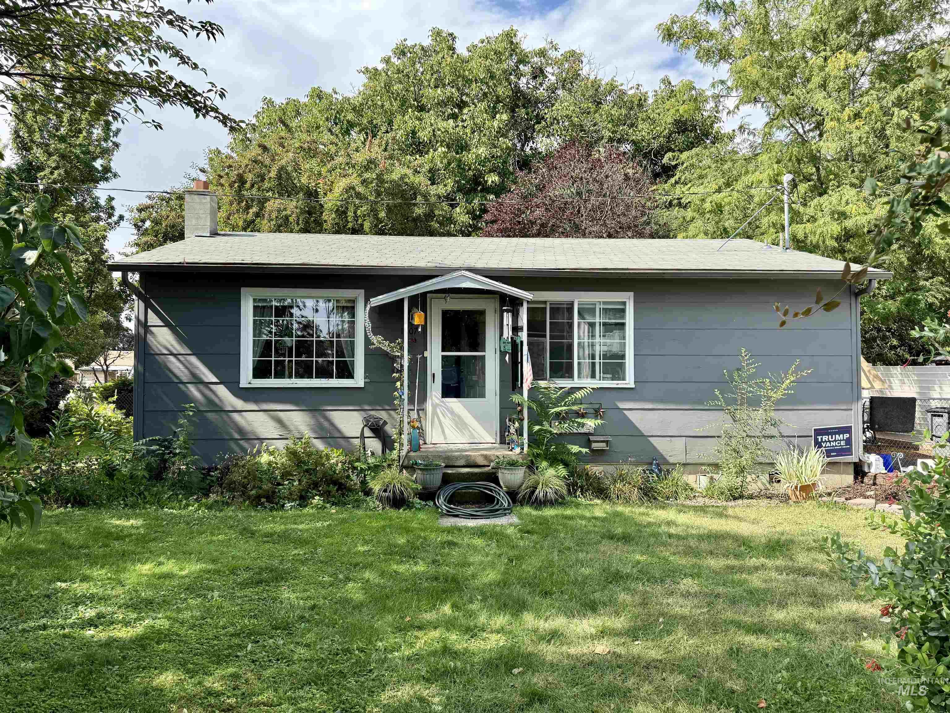 Single story home featuring a front lawn and a chimney