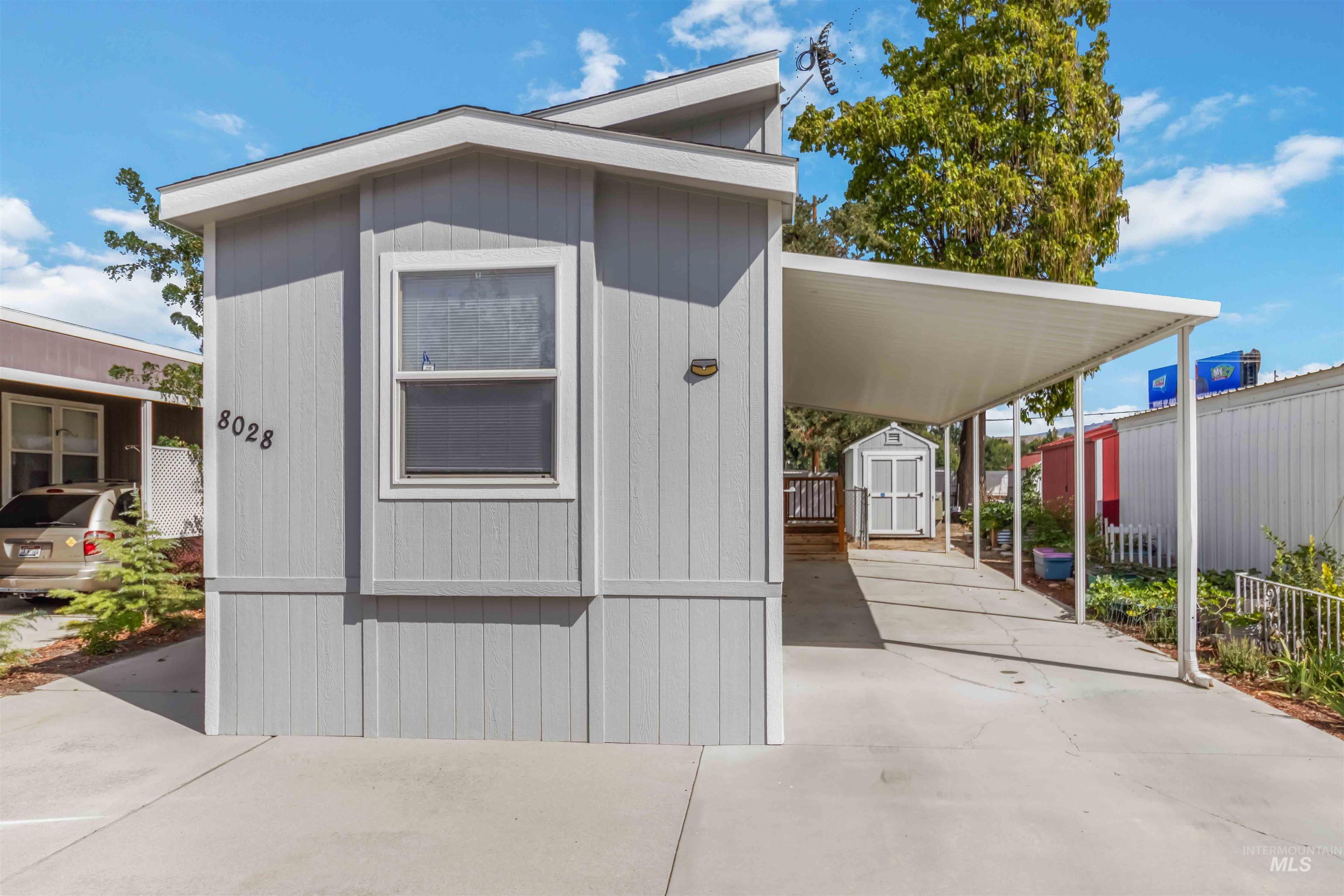 View of shed with concrete driveway and an attached carport