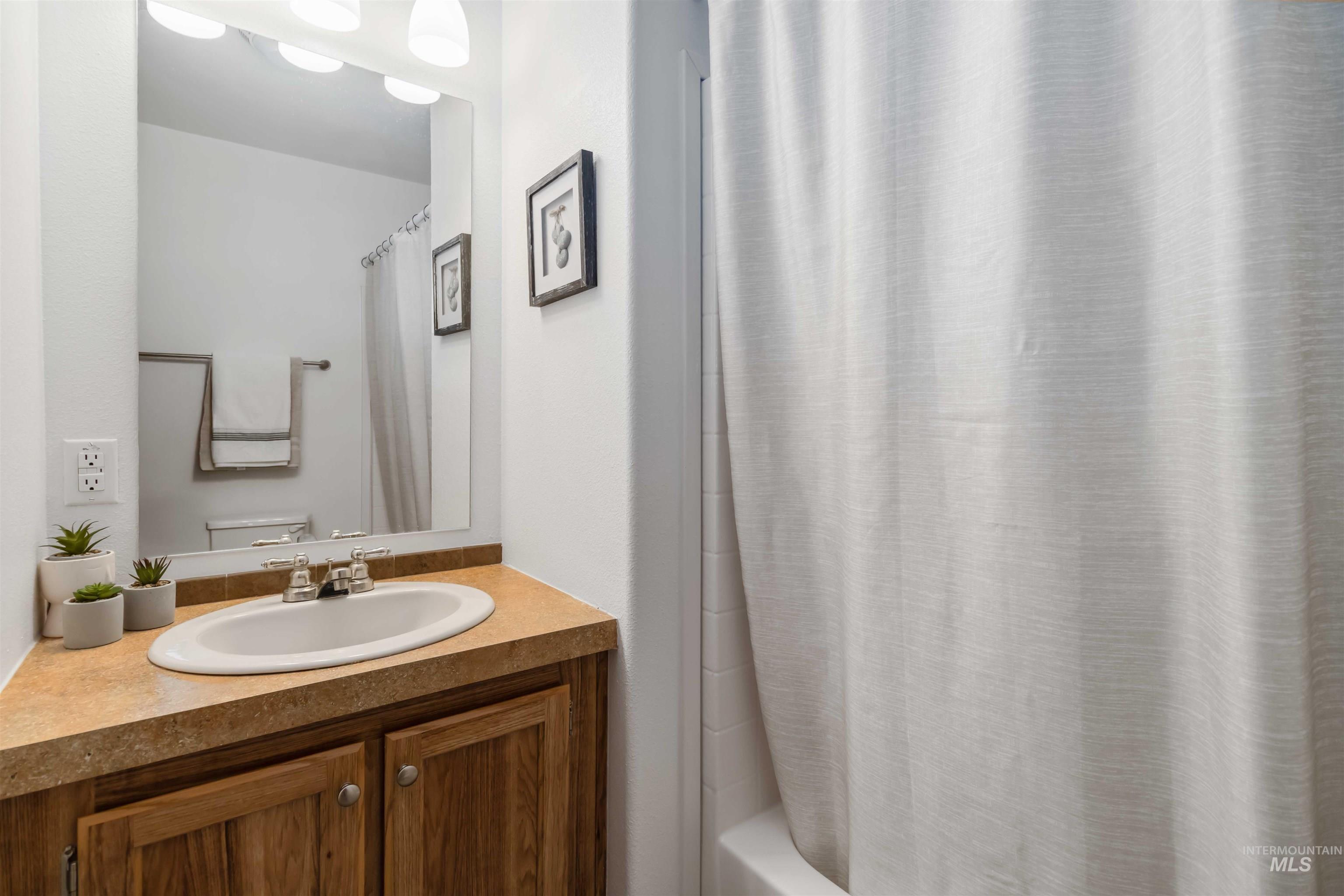 Bathroom featuring vanity and shower / bath combo with shower curtain