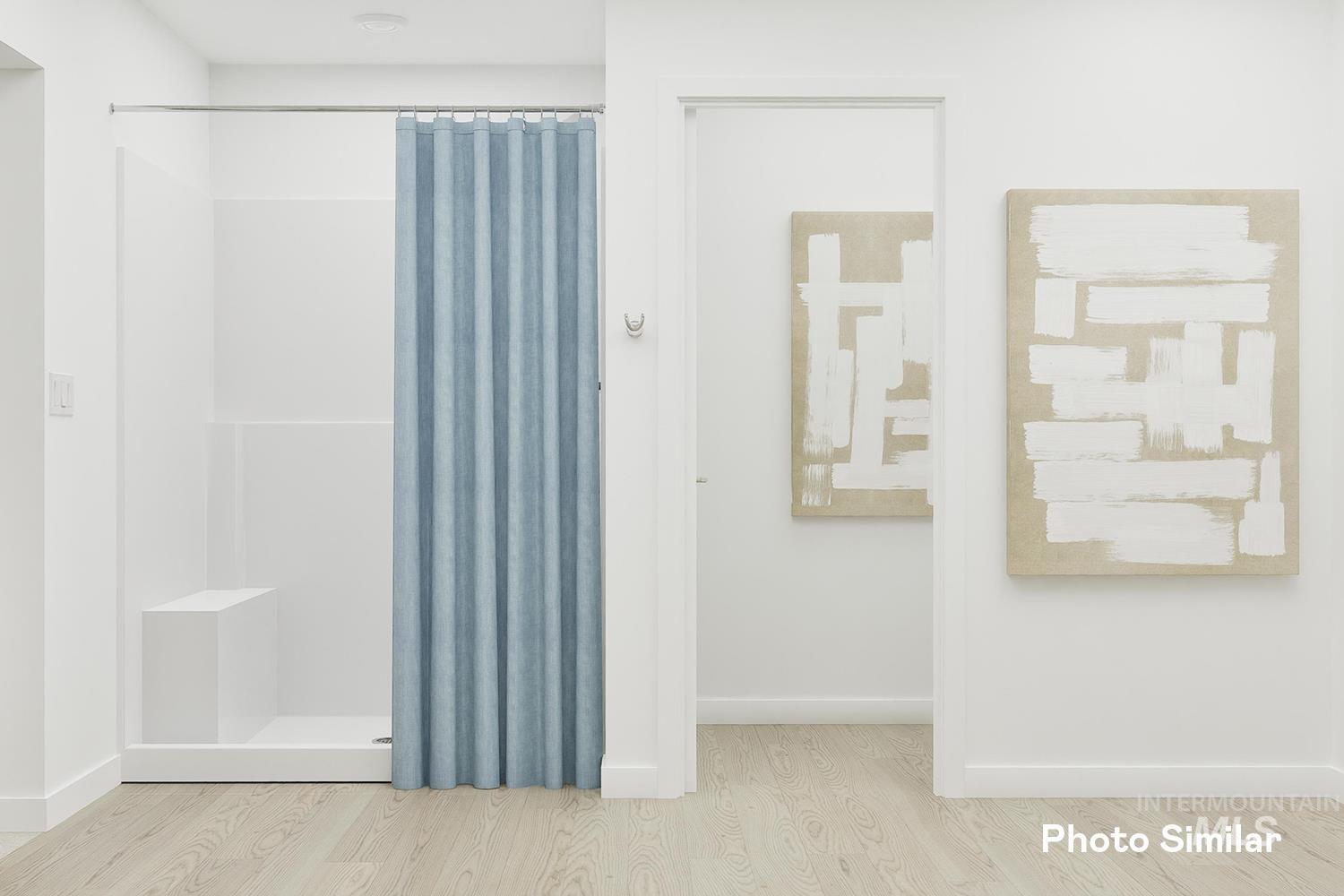 Bathroom with a shower stall and wood finished floors