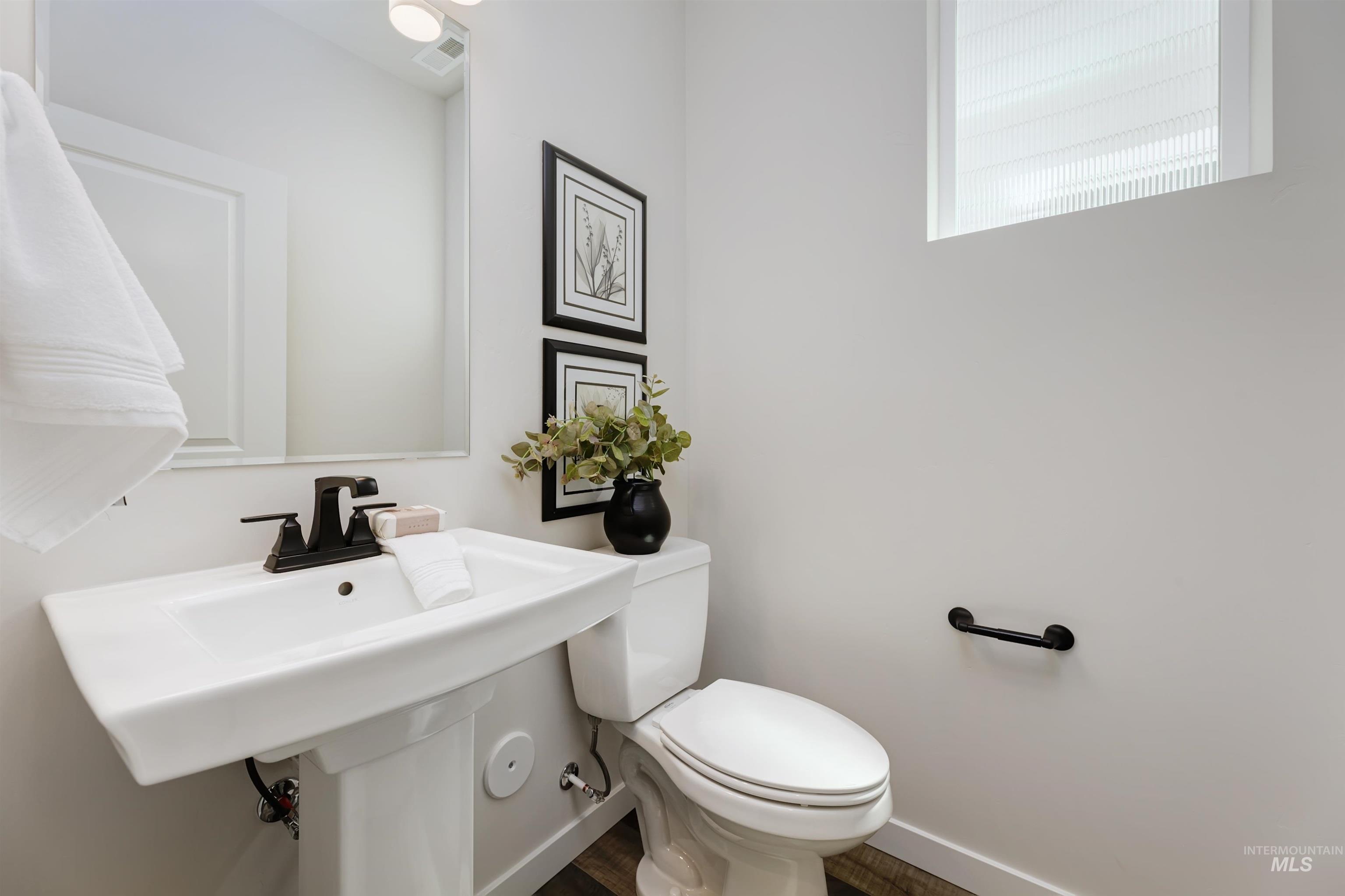 Bathroom with toilet and wood finished floors