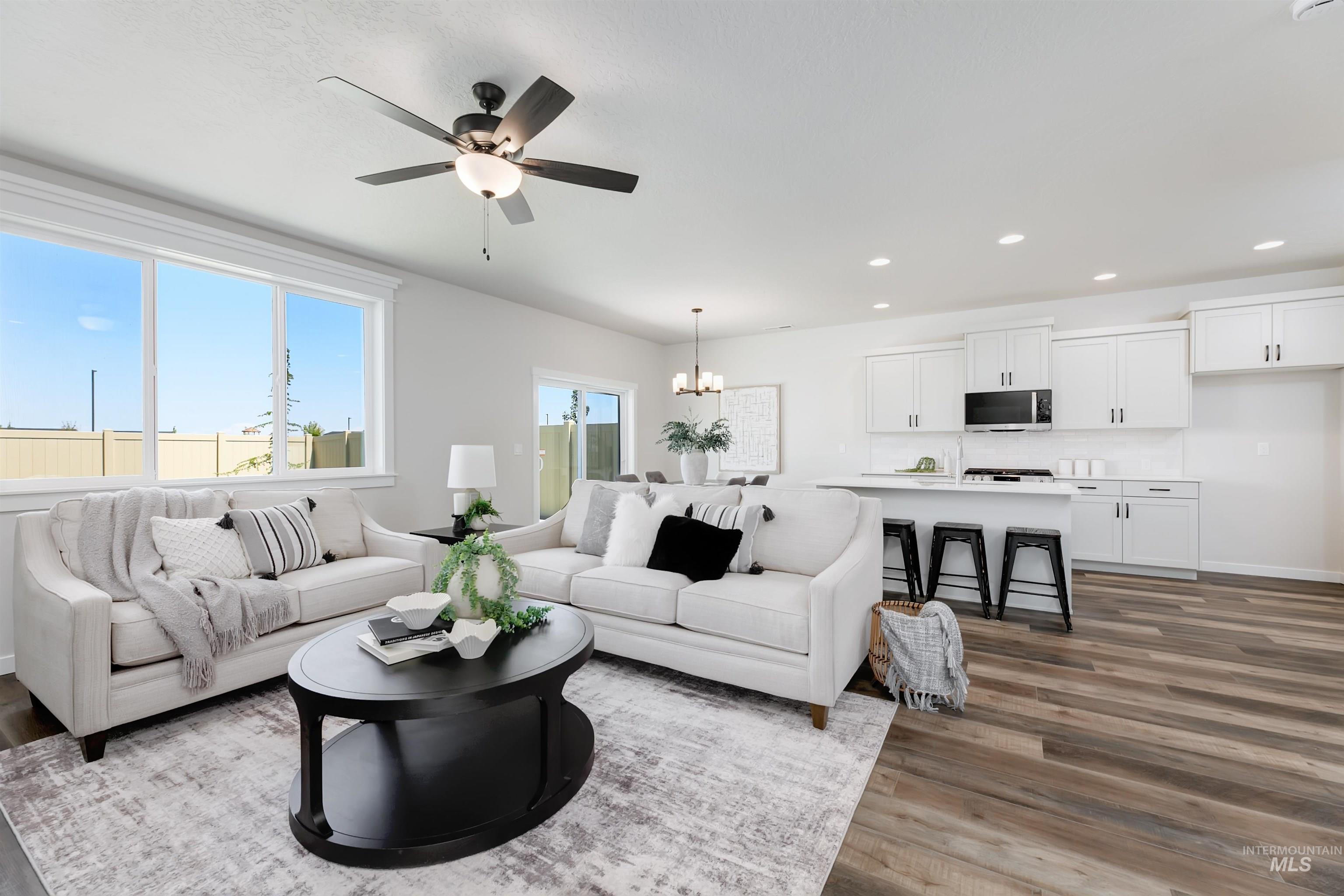 Living room with a chandelier, wood finished floors, ceiling fan, and recessed lighting