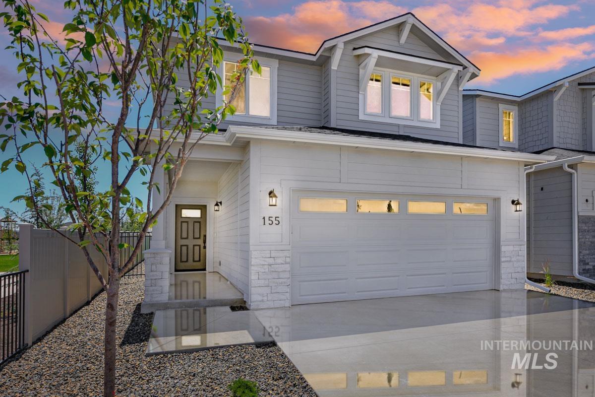 View of front of property featuring concrete driveway and an attached garage