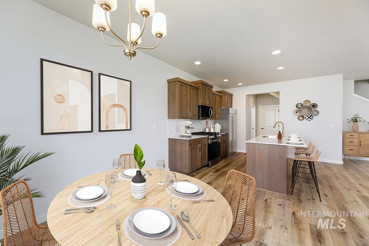 Dining space featuring light wood-type flooring, recessed lighting, and a chandelier