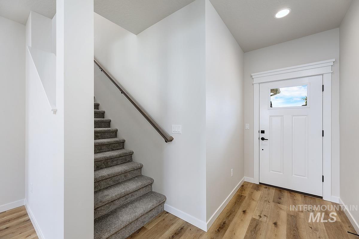 Foyer with stairs, light wood-type flooring, and recessed lighting