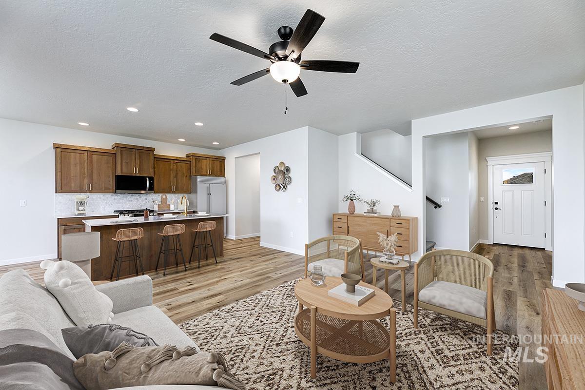 Living area with recessed lighting, light wood finished floors, ceiling fan, and a textured ceiling