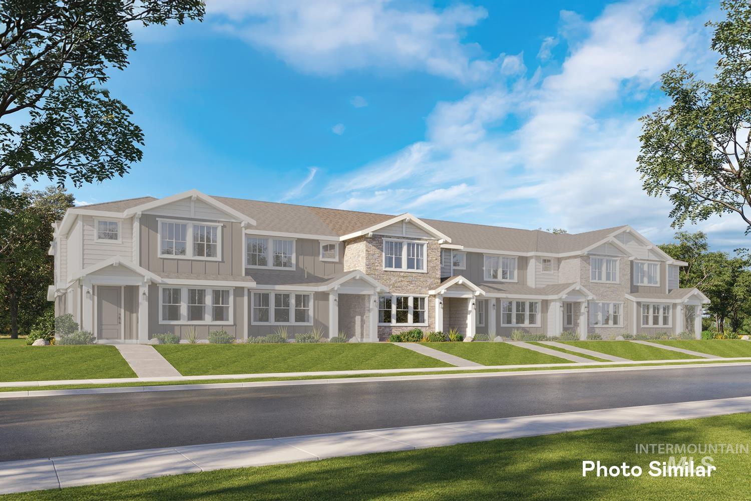 View of front of property with an attached garage, a front yard, and stone siding