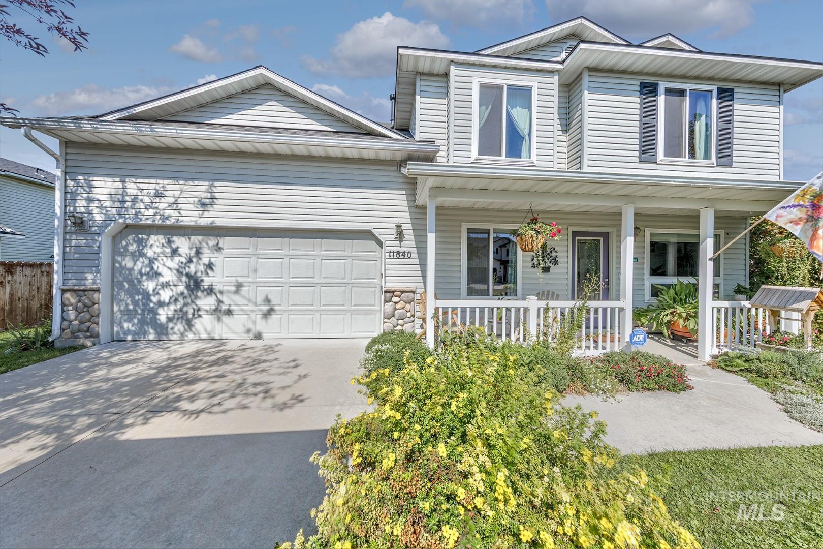 View of front of house featuring stone siding, concrete driveway, an attached garage, and a porch
