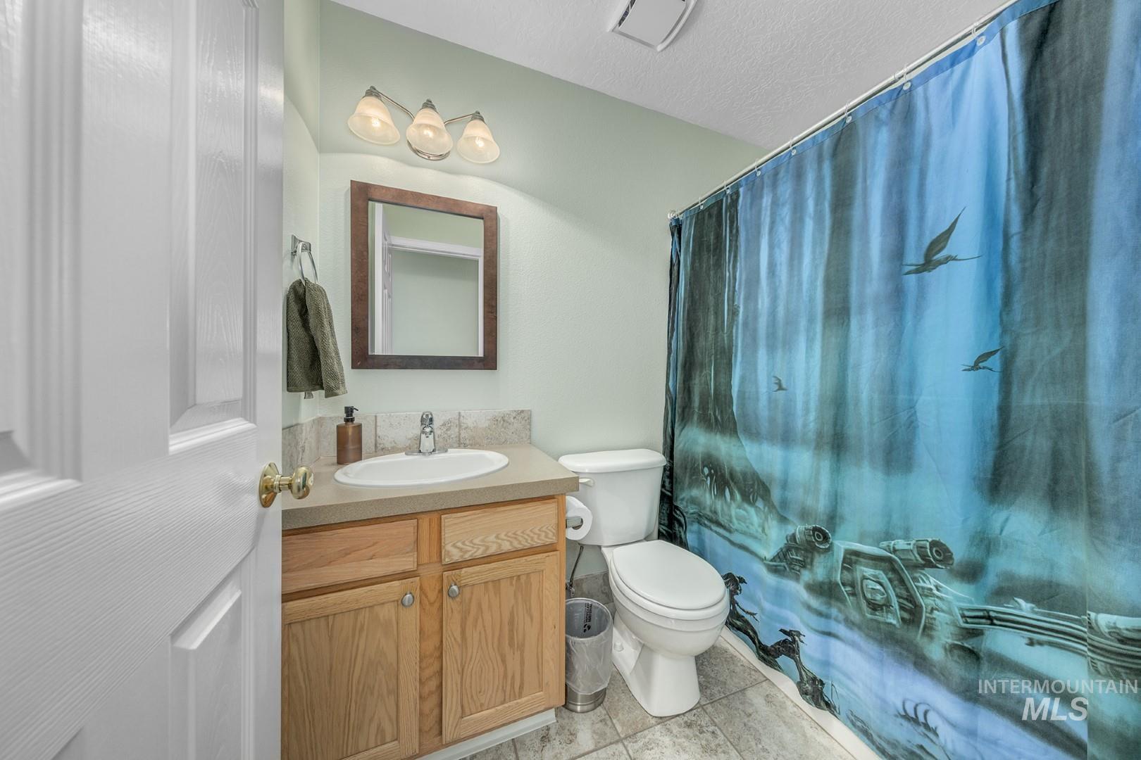 Bathroom with vanity, light tile patterned floors, and a textured ceiling