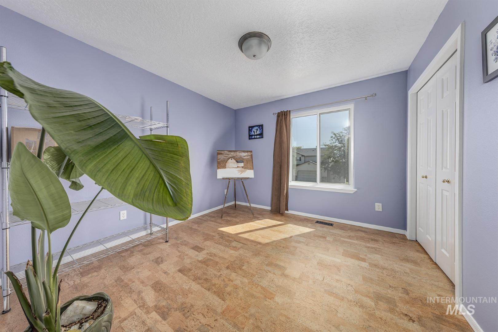 Unfurnished room with a textured ceiling and baseboards