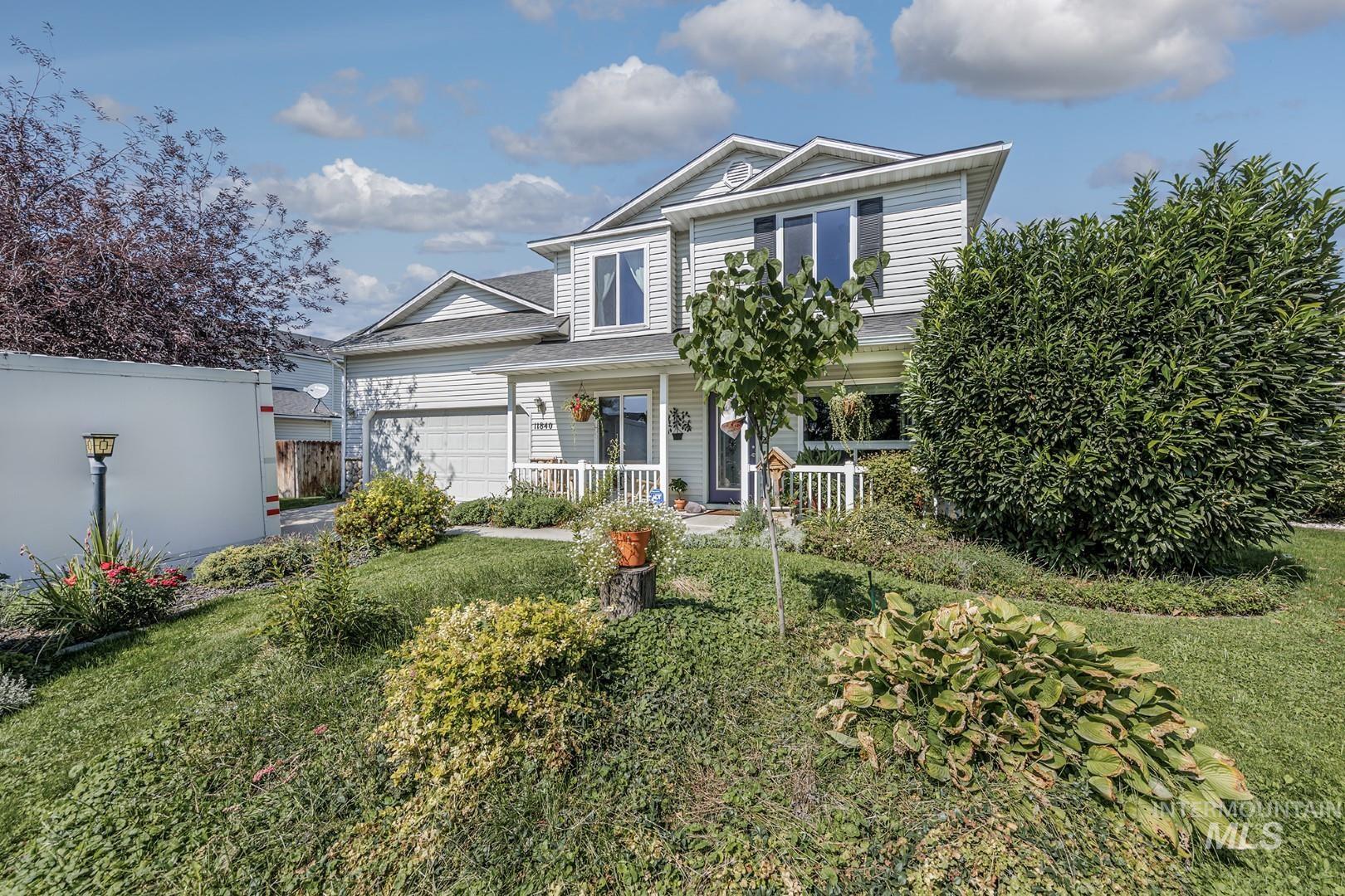 Traditional home featuring covered porch, a garage, and a front lawn