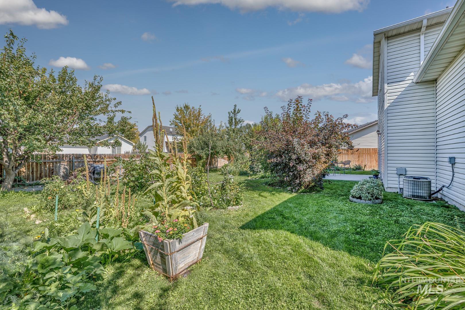 Fenced backyard featuring a garden