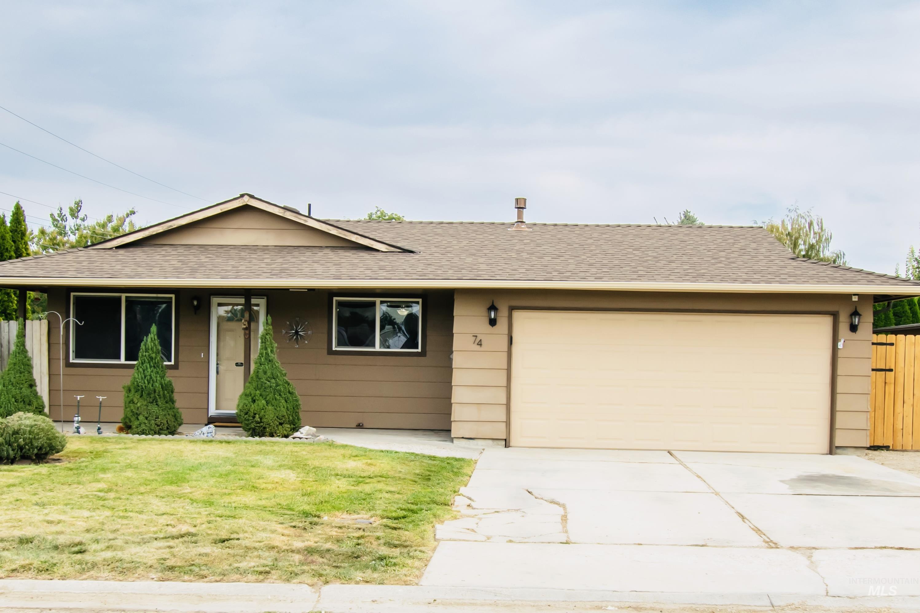 Ranch-style home with a shingled roof, driveway, and an attached garage