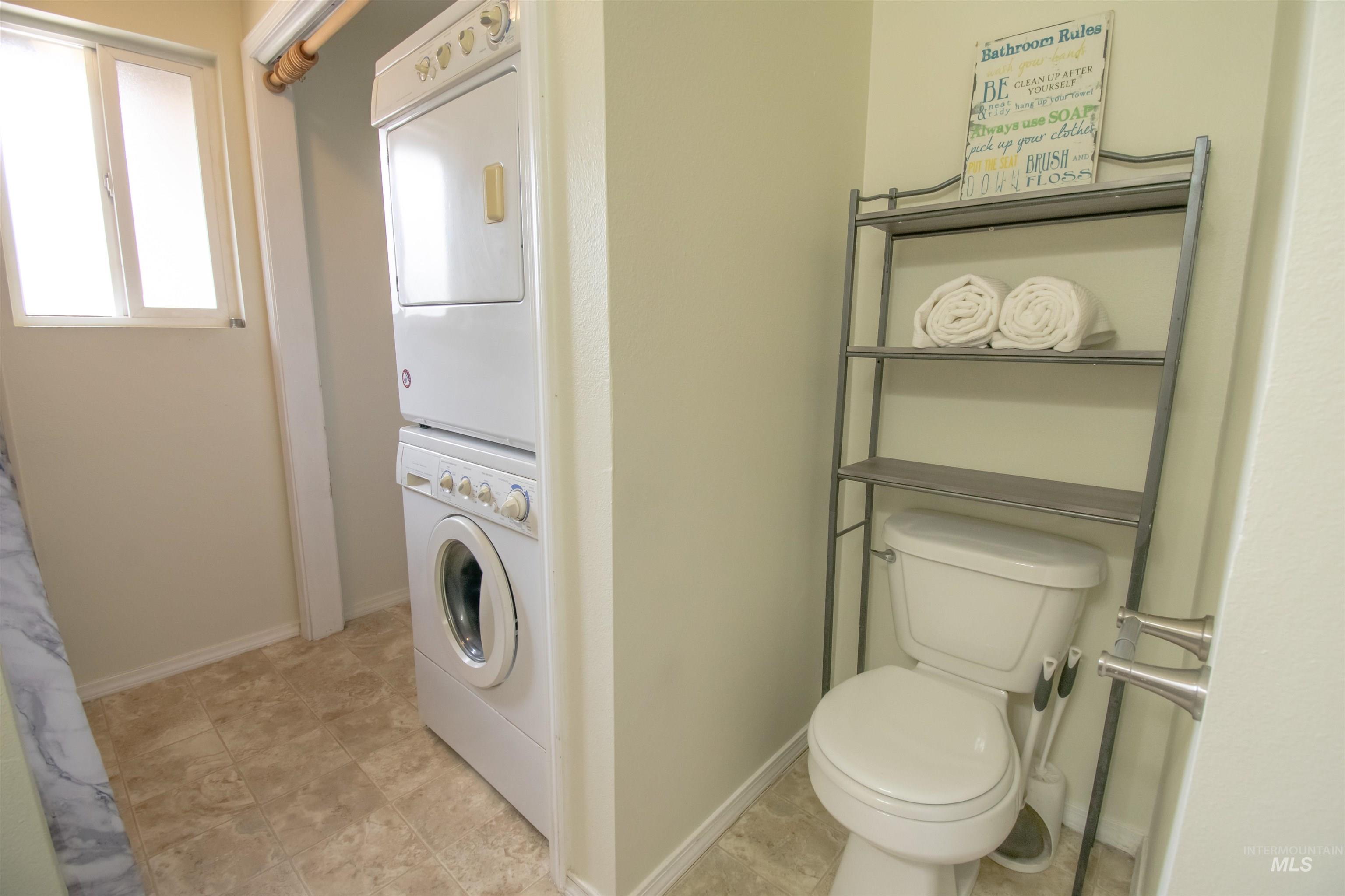 Bathroom with stacked washer / dryer and toilet
