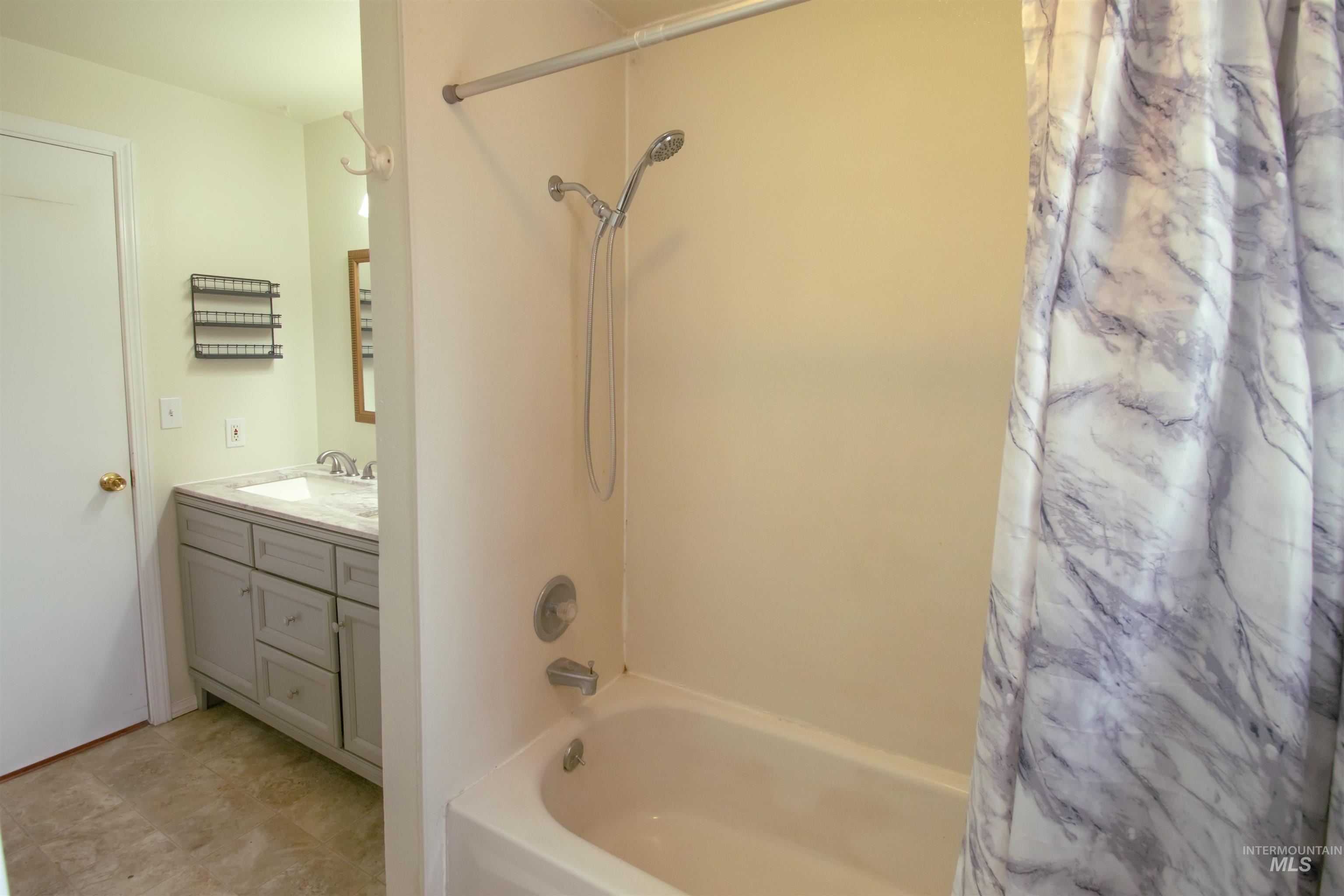 Bathroom with shower / bath combination with curtain and vanity