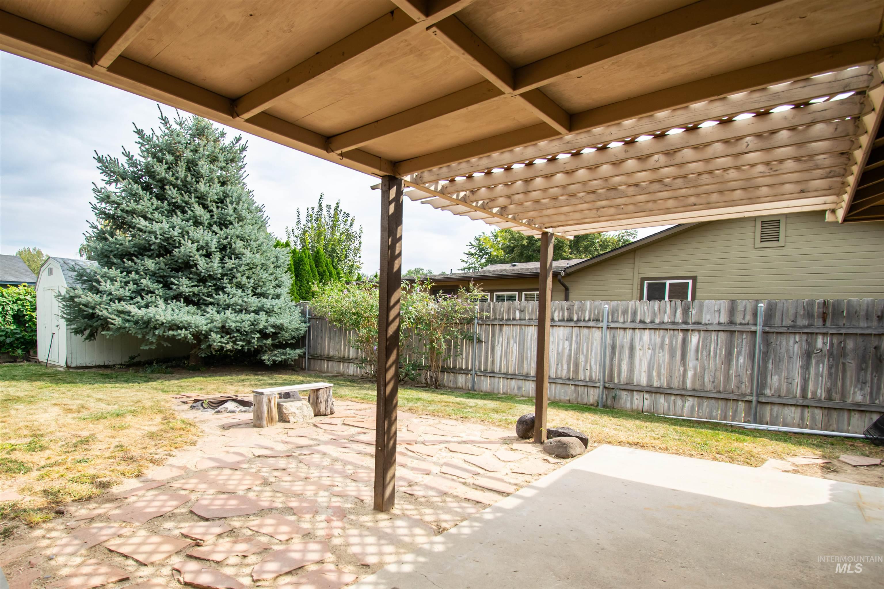 Fenced backyard featuring a pergola, a patio, and a shed