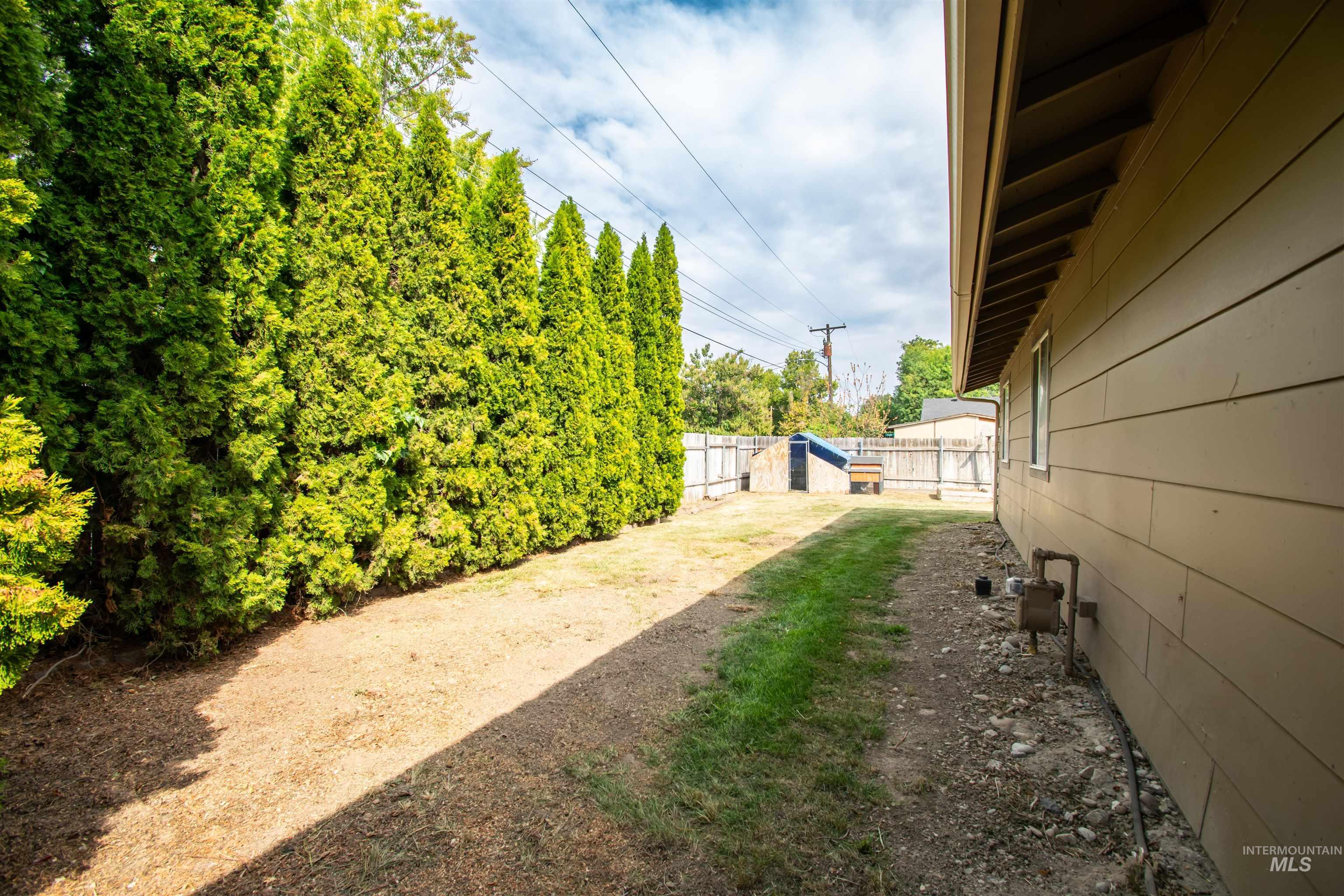 Fenced backyard featuring a storage unit
