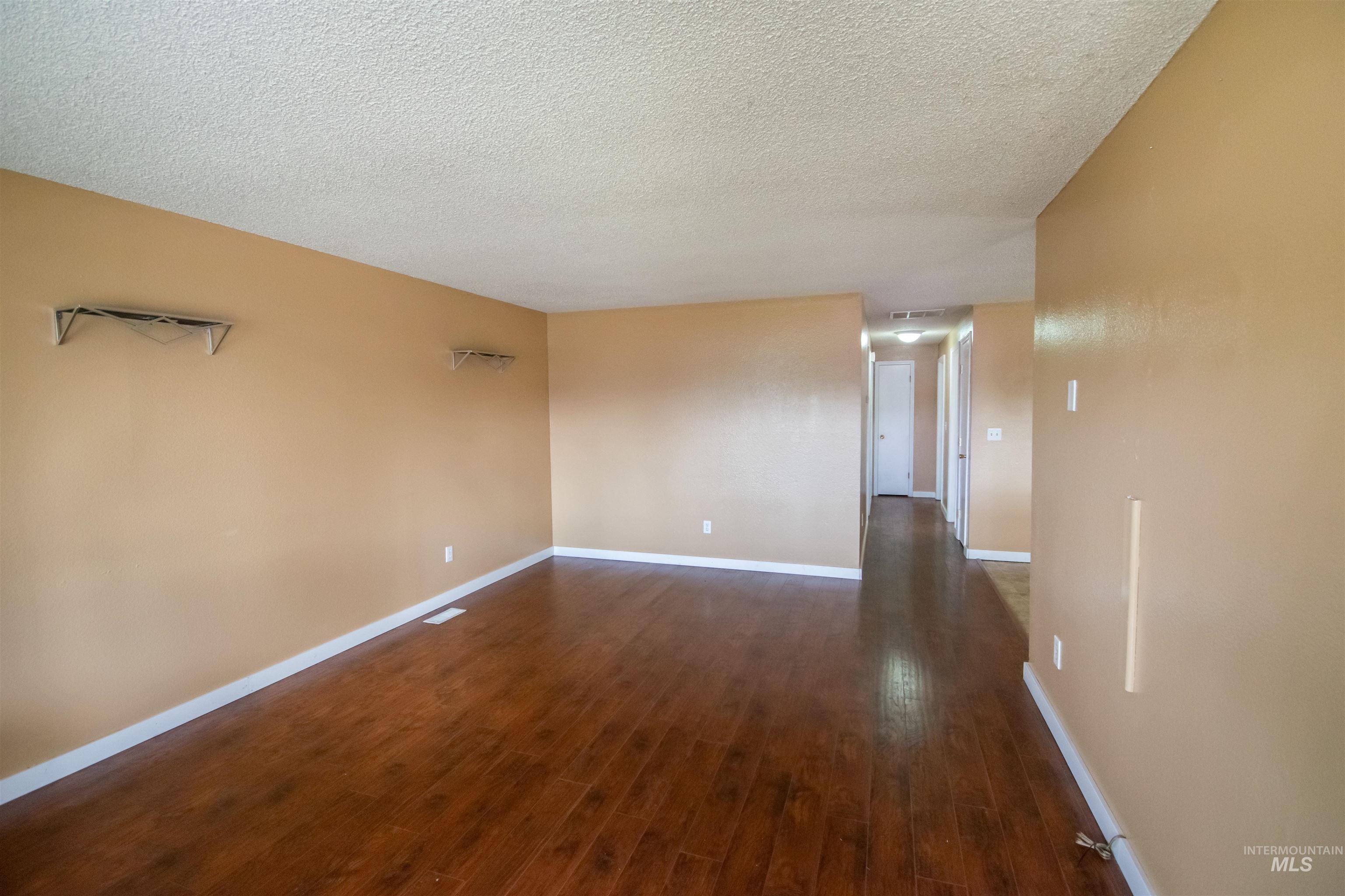 Empty room with dark wood-style floors and a textured ceiling